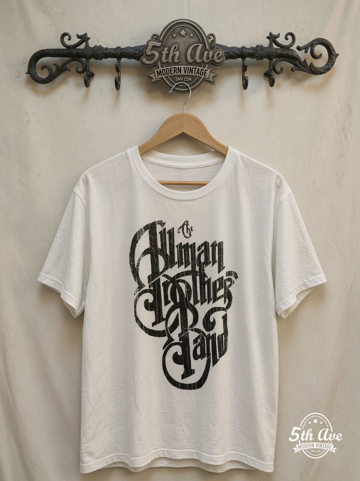 The Allman Brothers Band Black Distressed Script Logo vintage band t-shirt in black, front view on a display rack
