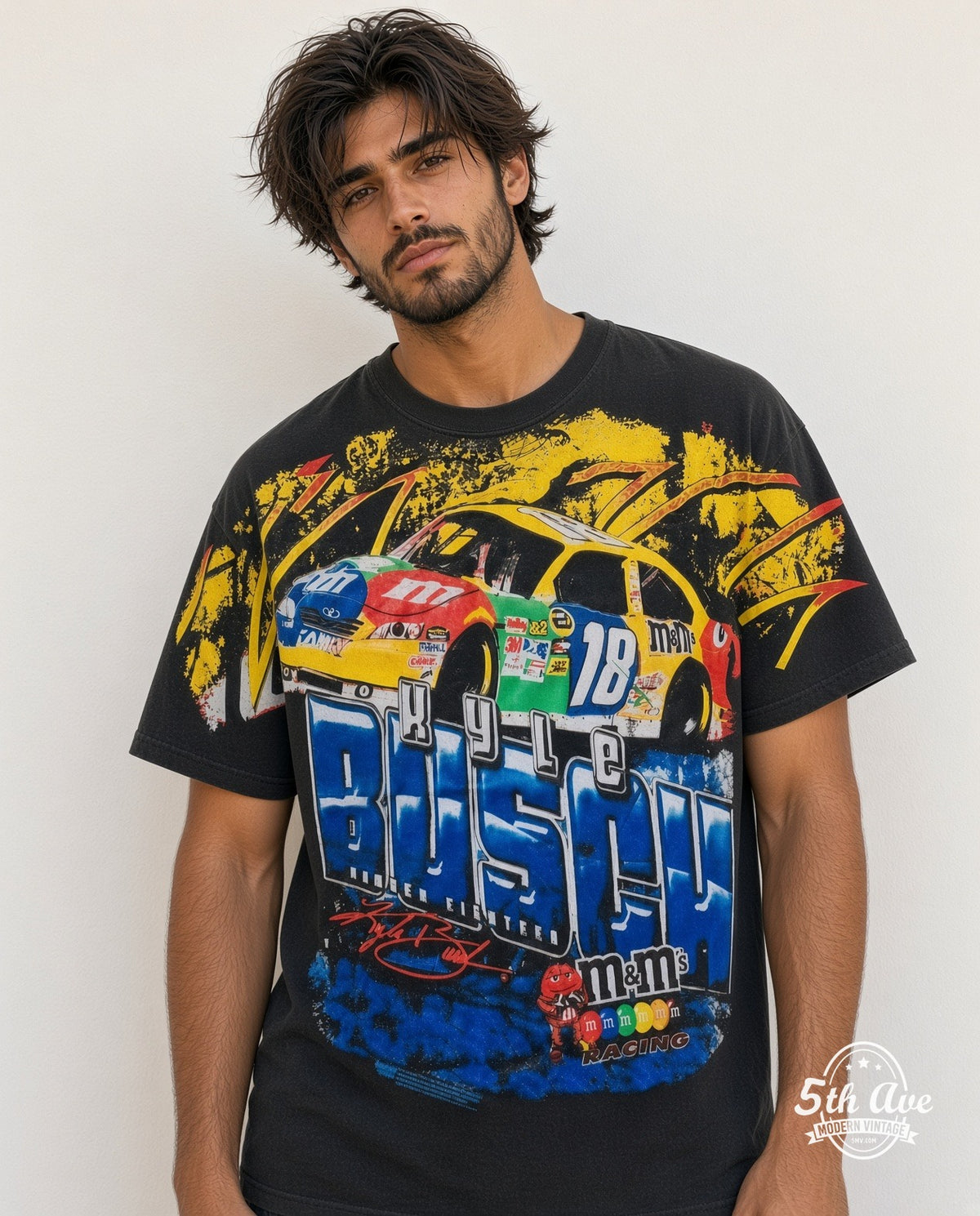Model wearing the NASCAR Kyle Busch #18 M&M's Block Name all-over-print NASCAR t-shirt in black