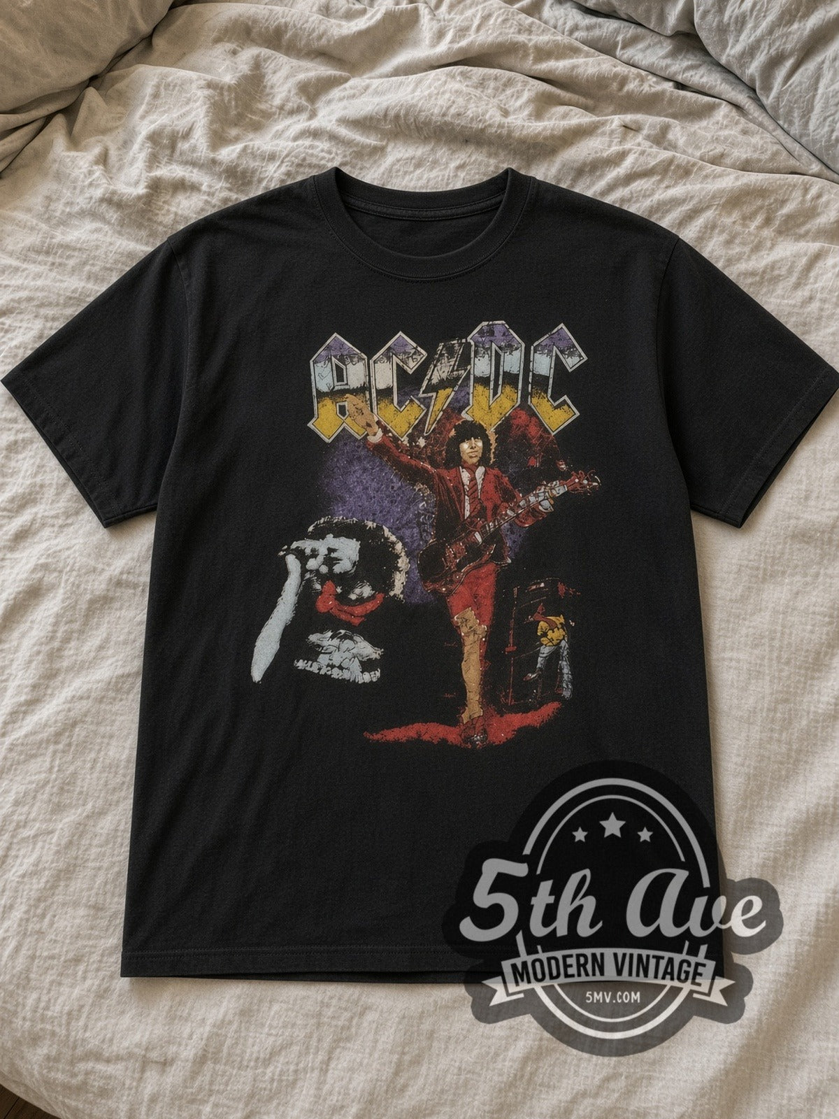 Black AC/DC Angus Young Red Schoolboy Purple Haze Vintage Band T-Shirt laid flat on a linen bed