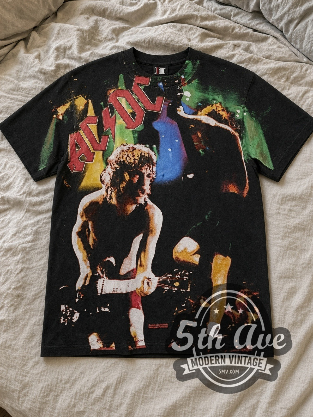 Black AC/DC Angus Young Shreds All Over Print Vintage Band T-Shirt laid flat on a linen bed