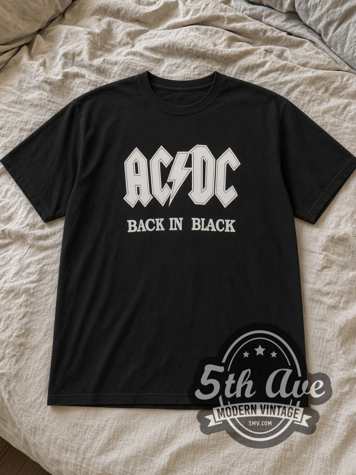 Black AC/DC Classic Back In Black Vintage Band T-Shirt laid flat on a linen bed