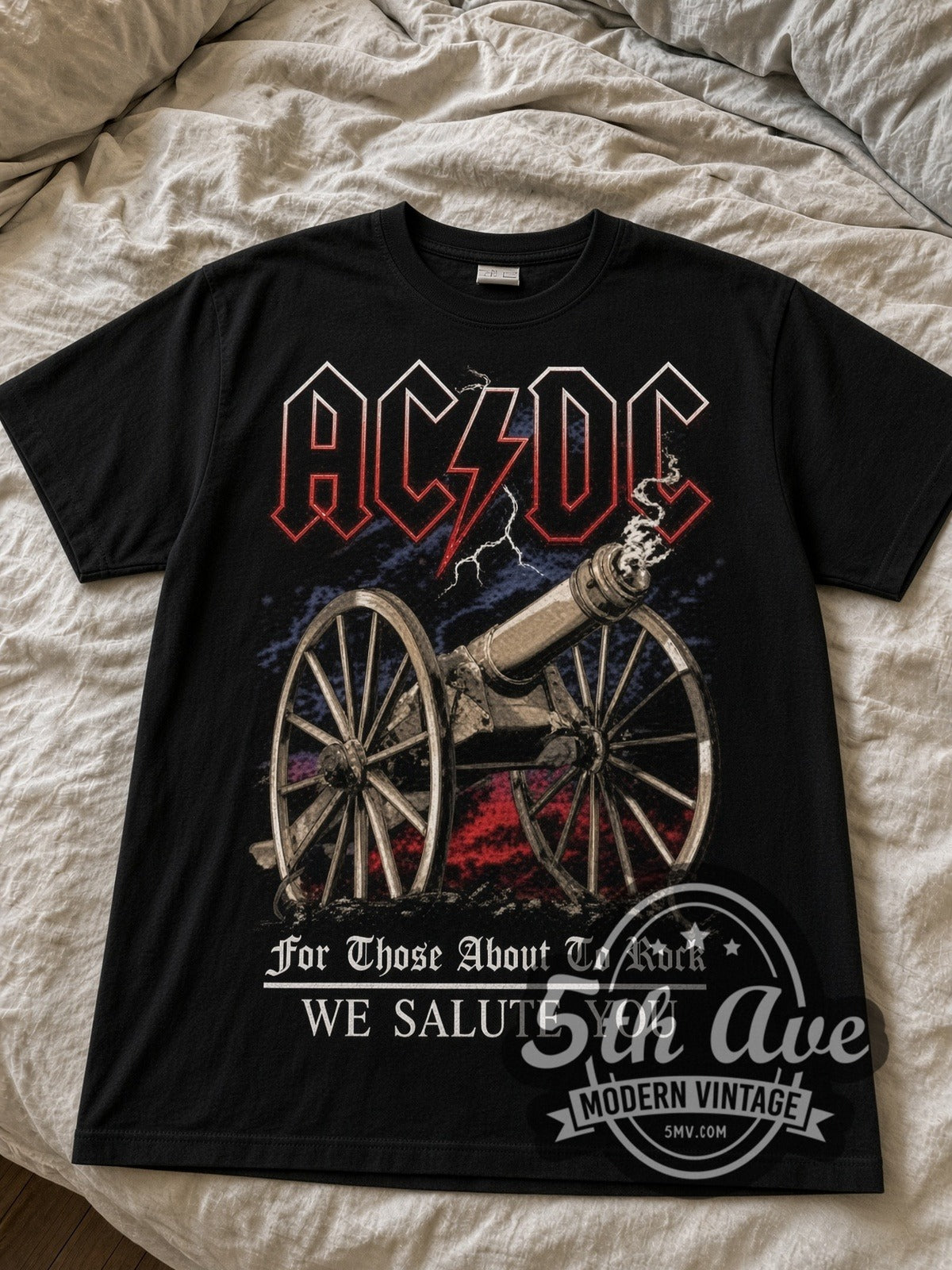 AC/DC For Those About to Rock Cannon black graphic tee laid flat on linen bed