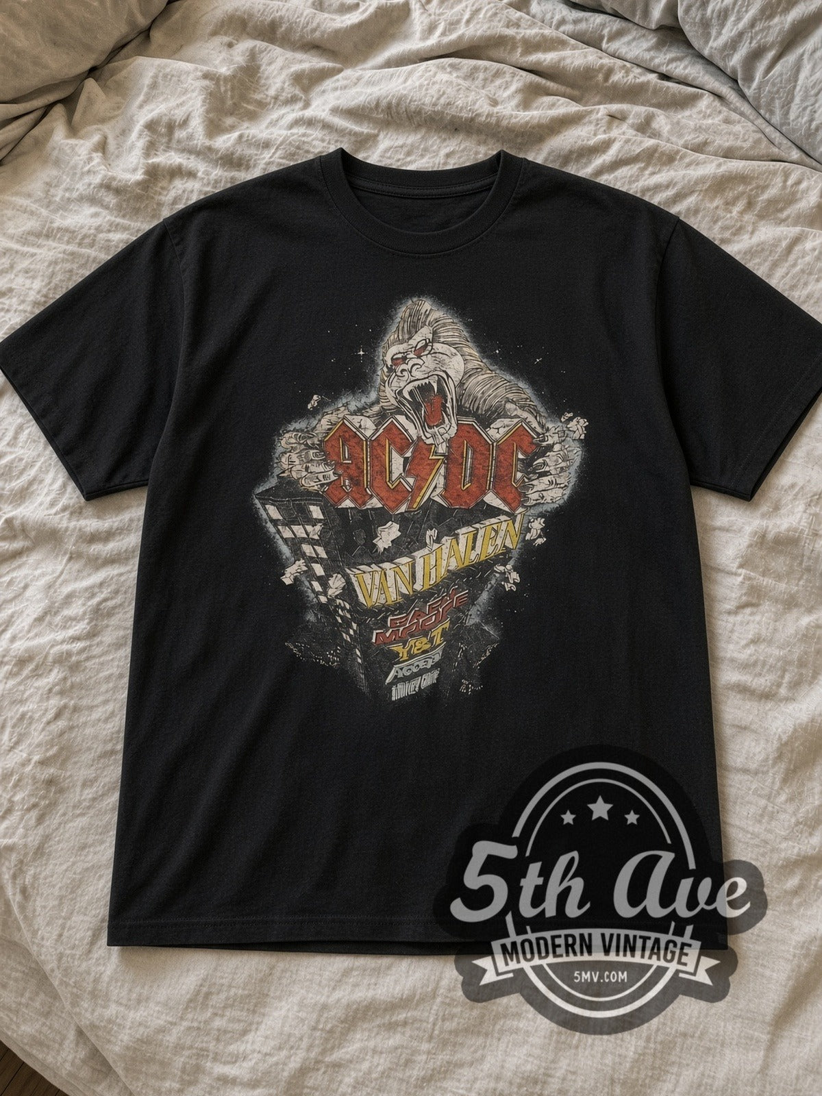 Black AC/DC Monsters of Rock Vintage Band T-Shirt laid flat on a linen bed