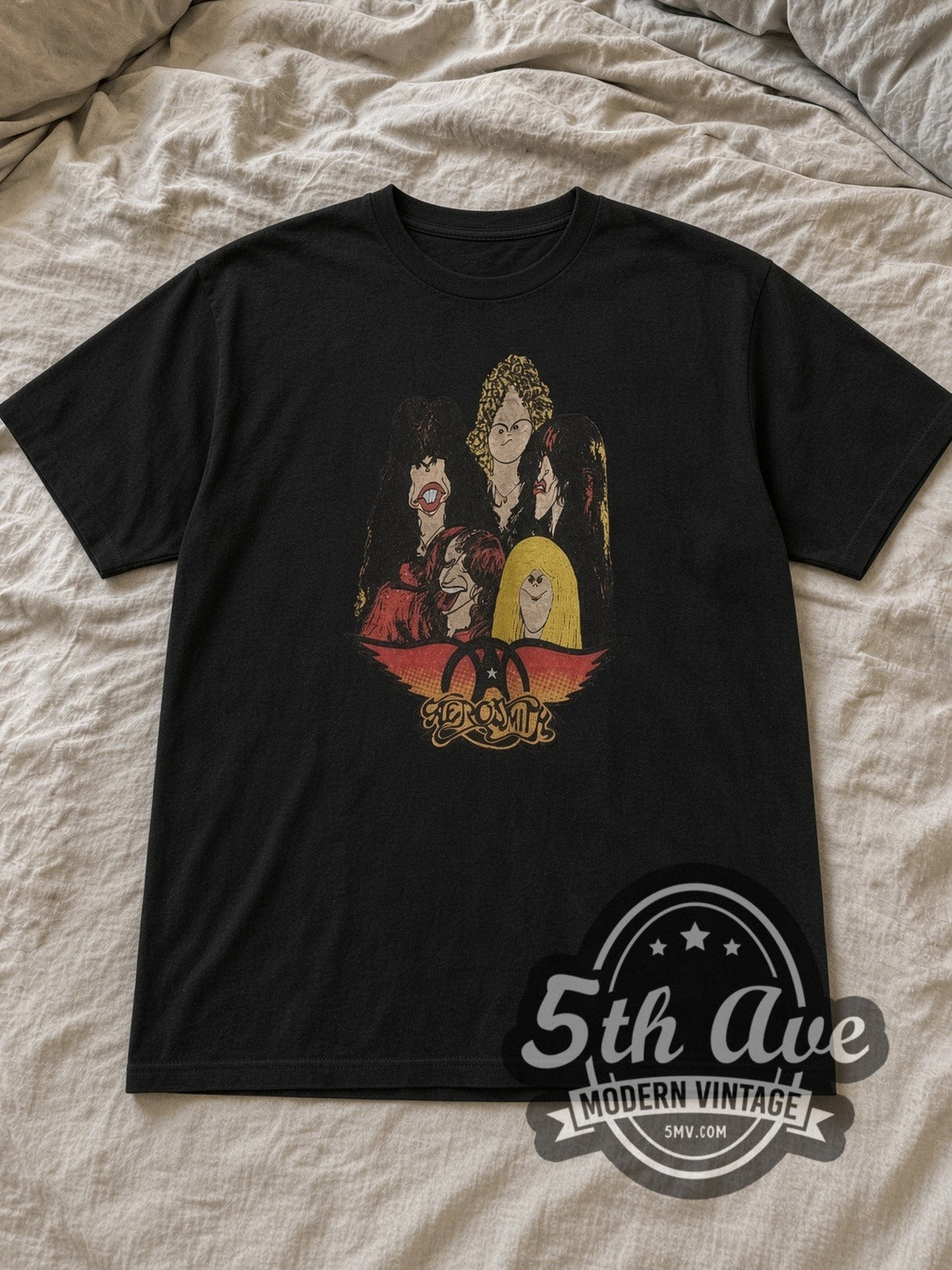 Black Aerosmith Cartoon Caricatures Vintage Band T-Shirt laid flat on a linen bed