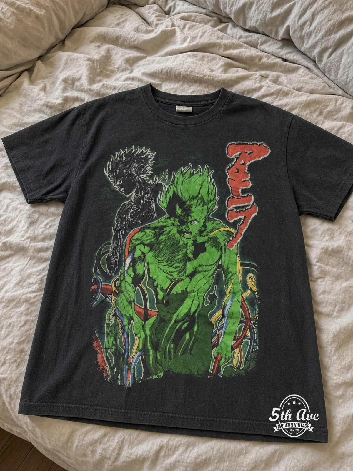 Akira Green Mutated Tetsuo Mech Arm vintage tee laid on bed