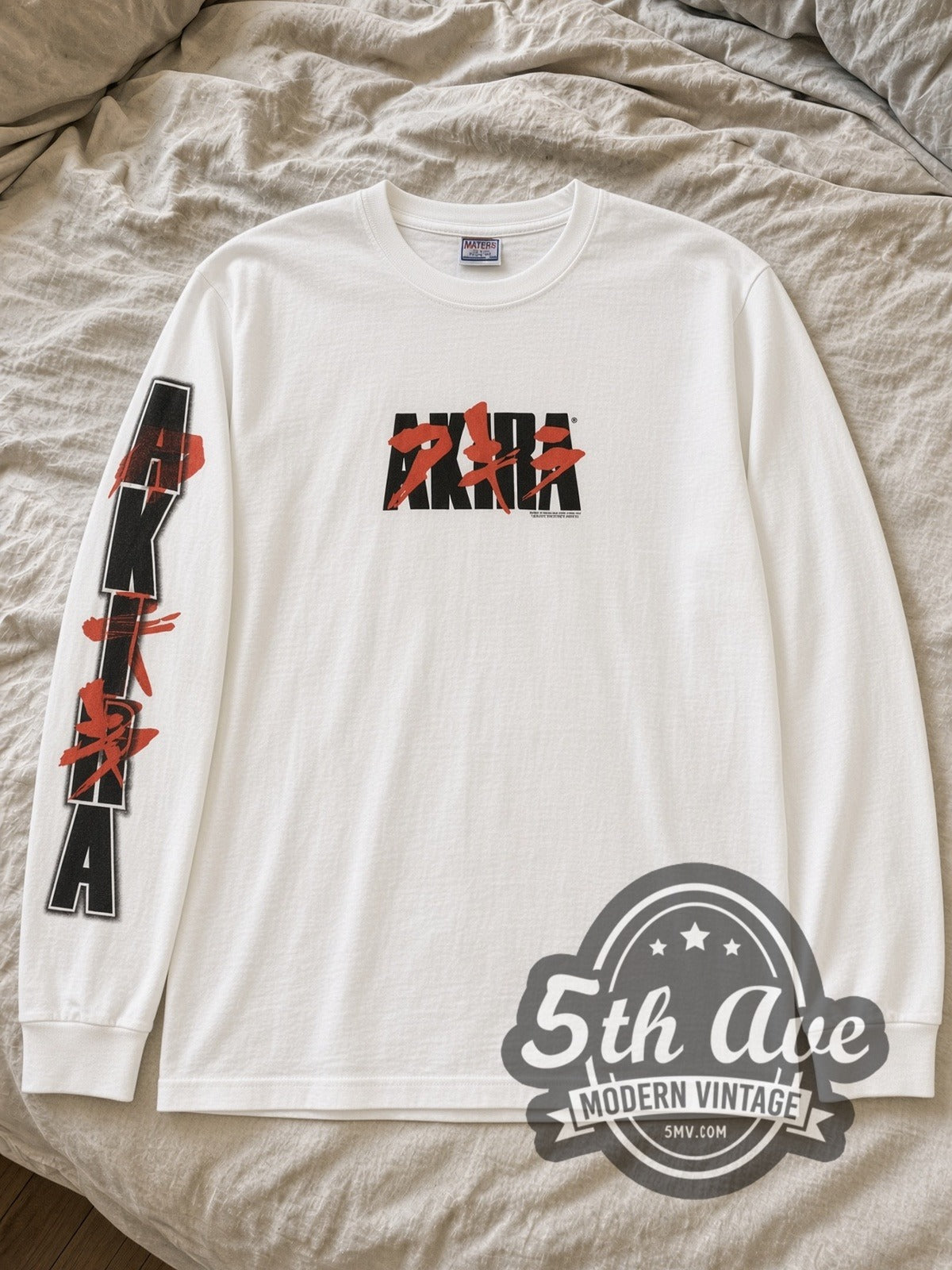 White Akira Kaneda bike long sleeve laid flat on linen bed