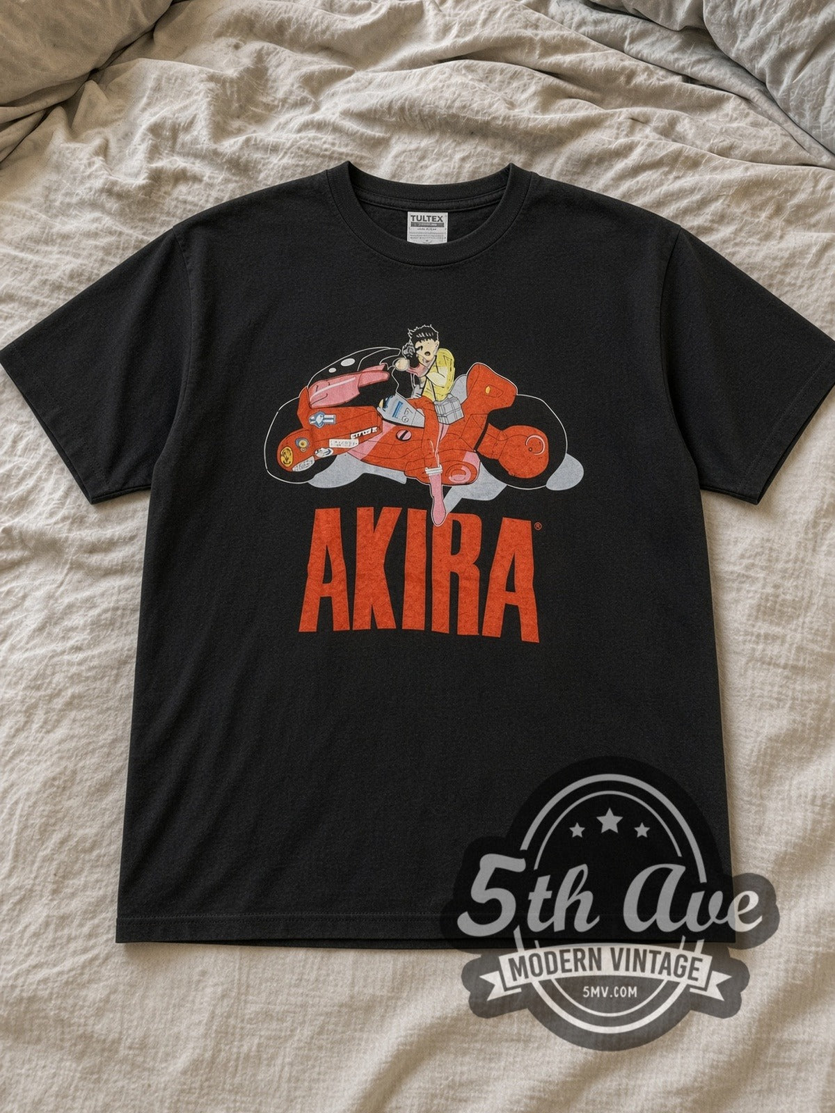 Black Akira Kaneda Motorcycle Logo Vintage Anime T-Shirt laid flat on a linen bed