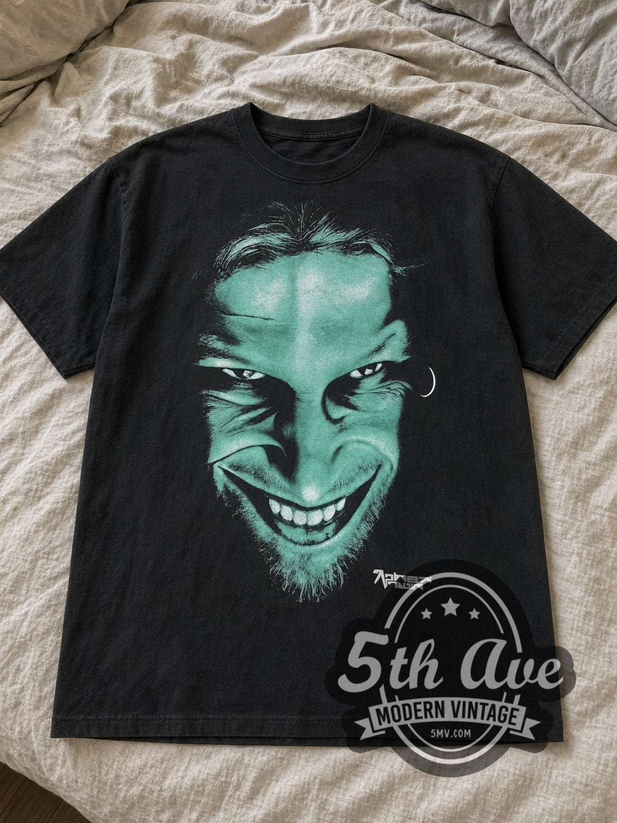 Black Aphex Twin Richard D. James Grin & Logo tee laid flat on linen bed