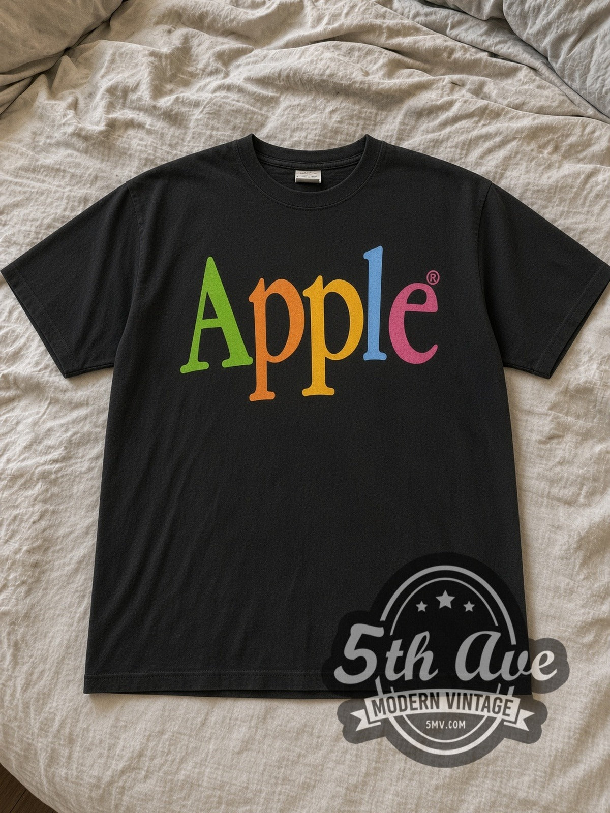 Black Apple Rumba Apple Rumba Vintage Graphic T-Shirt laid flat on a linen bed