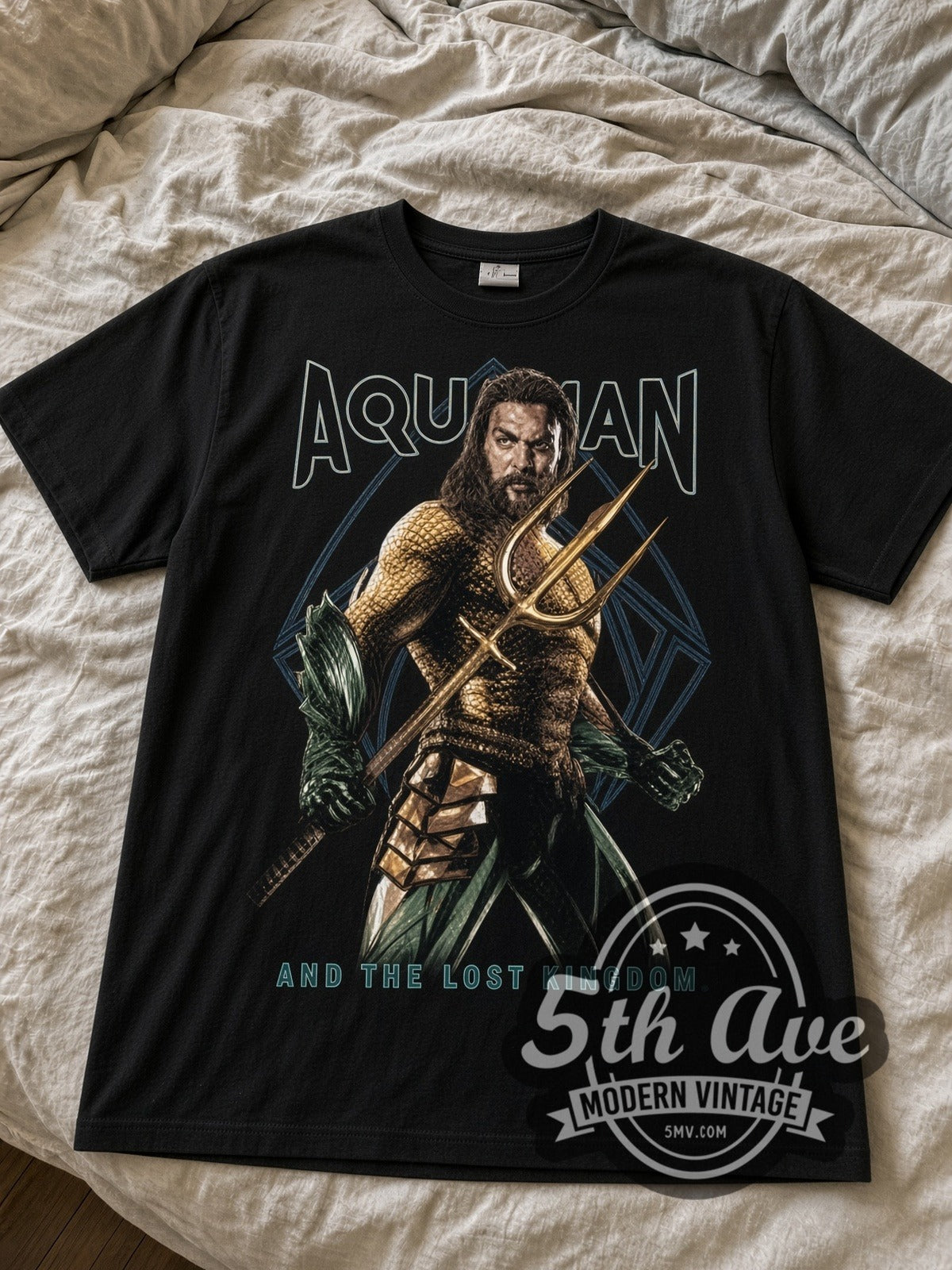 Aquaman and the Lost Kingdom black graphic tee laid flat on linen bed