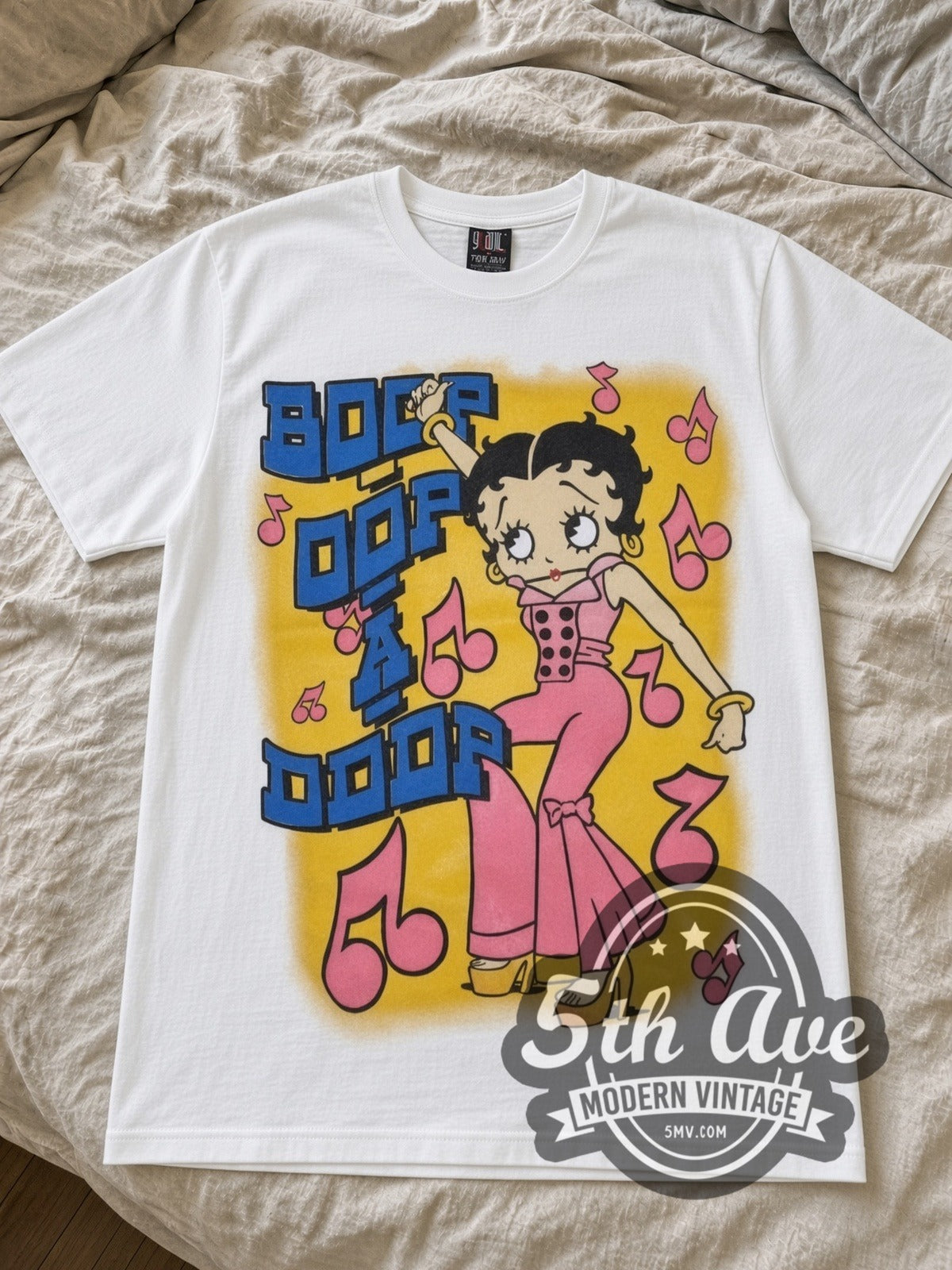 Betty Boop Boop Oop A Doop Music is Life cartoon tee in white laid flat on a bed, front artwork