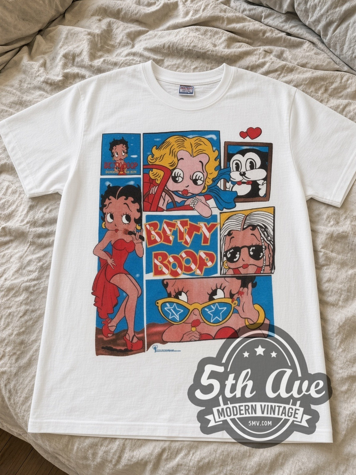 Betty Boop Comic Collage cartoon tee in white laid flat on a bed, front artwork