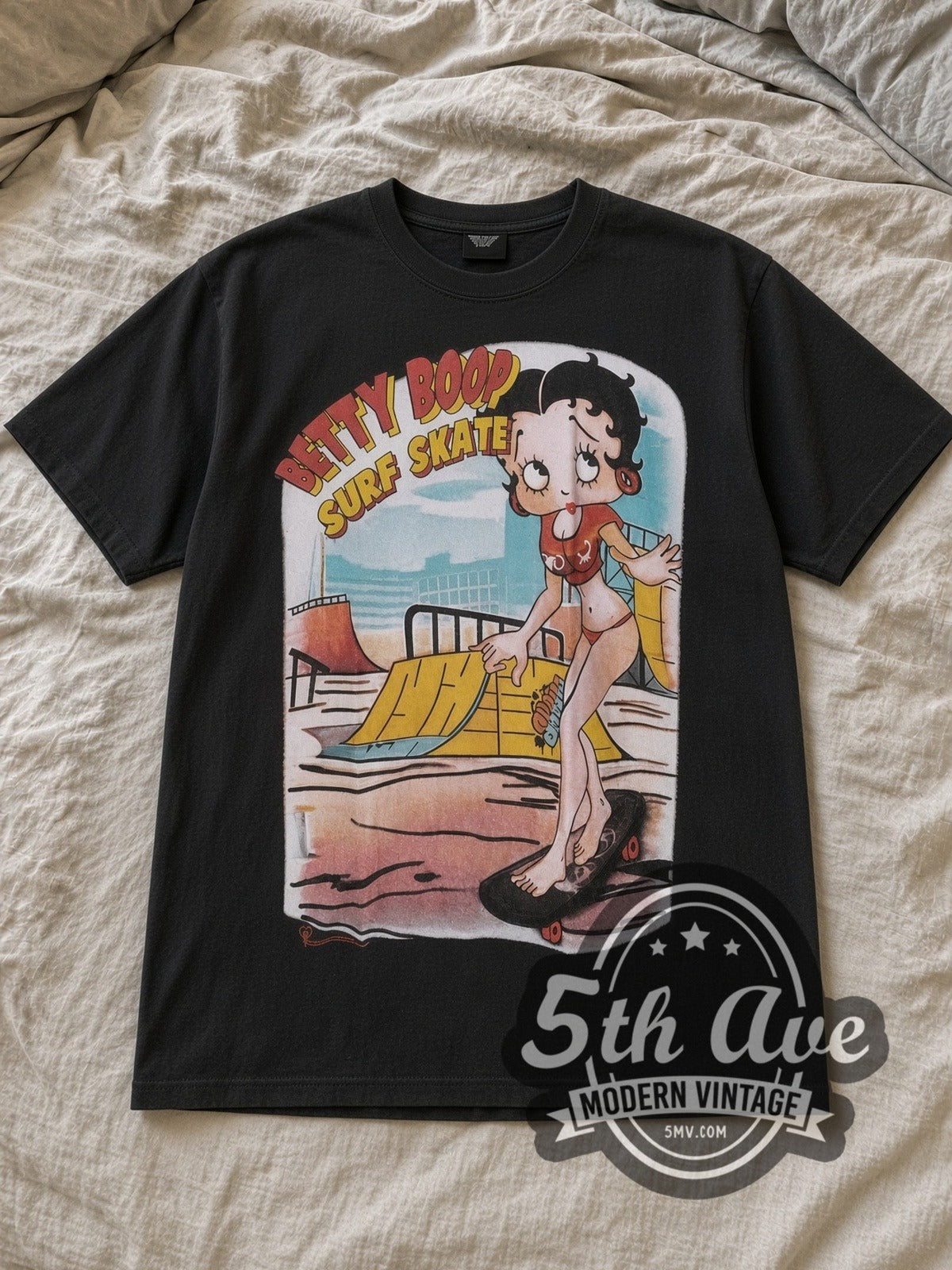 Black Betty Boop I'm Good at Surf Skate Vintage Cartoon T-Shirt laid flat on a linen bed
