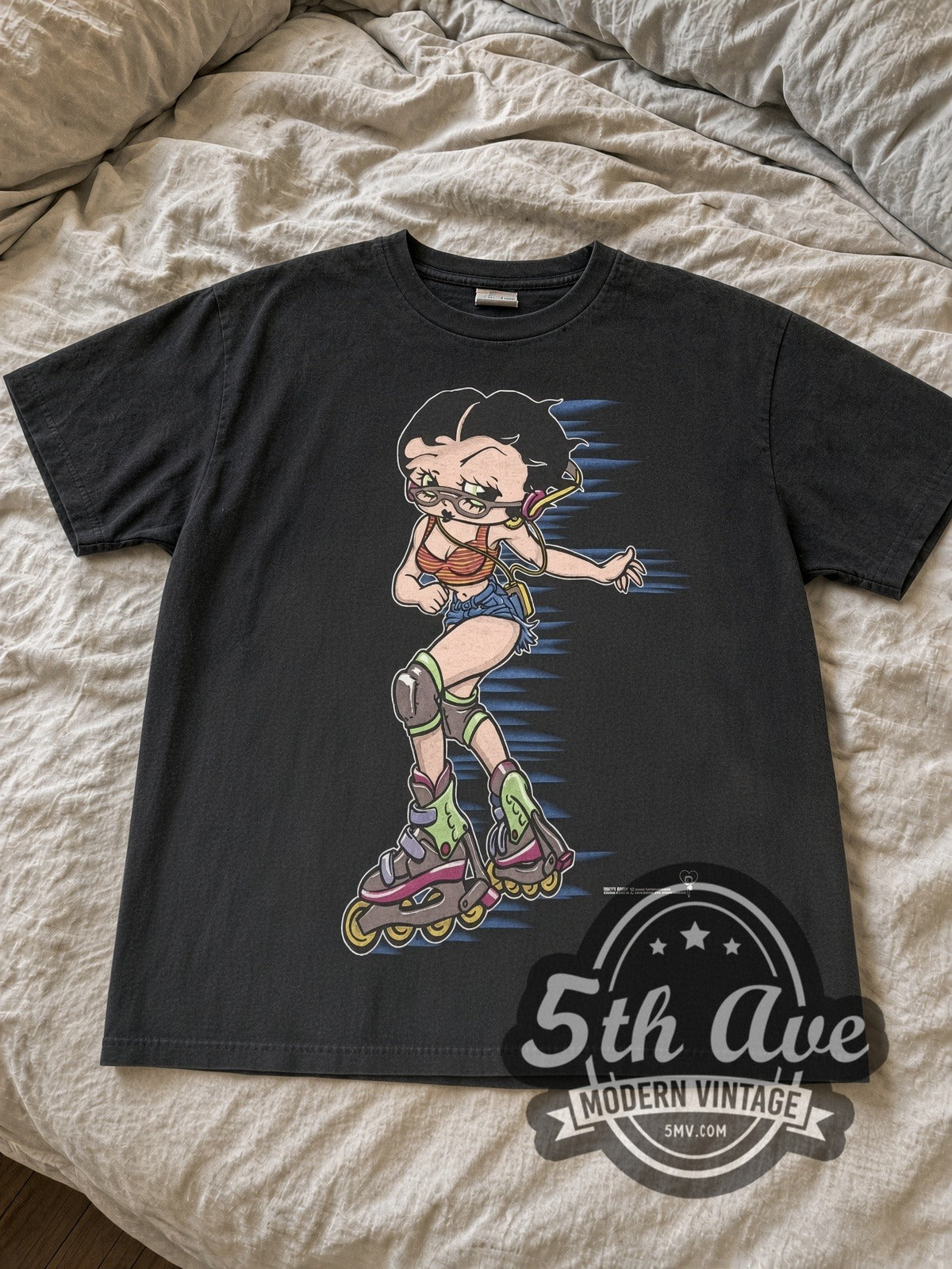 Faded black Betty Boop rollerblading tee laid flat on linen bed