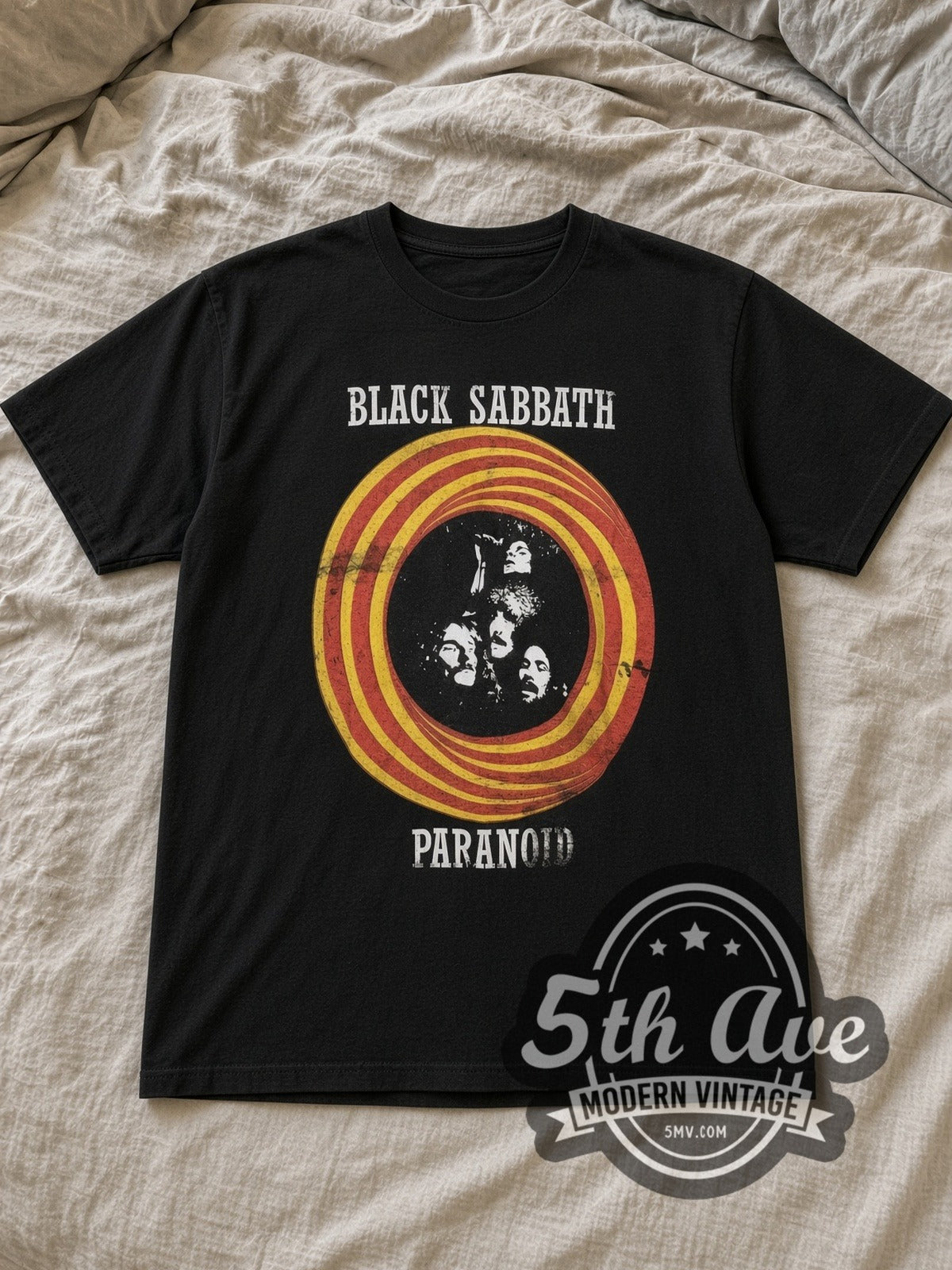 Black Sabbath Paranoid Vintage Band T-Shirt in black, laid flat on a linen bed