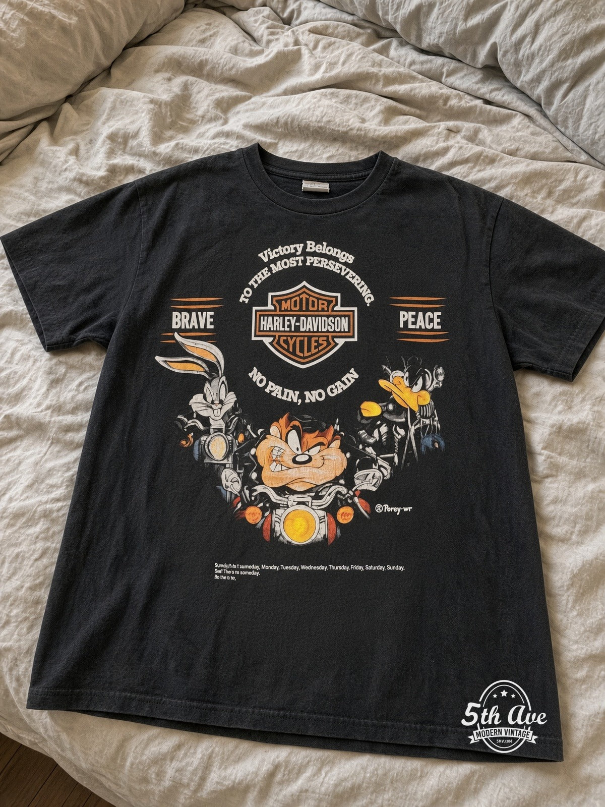 Harley-Davidson Looney Tunes Victory Belongs To The Most Persevering vintage tee laid on bed