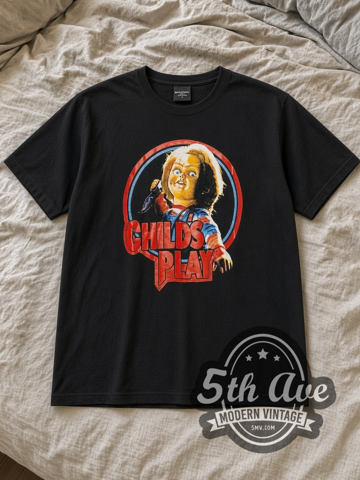 Black Child's Play Chucky Logo Vintage Movie T-Shirt laid flat on a linen bed