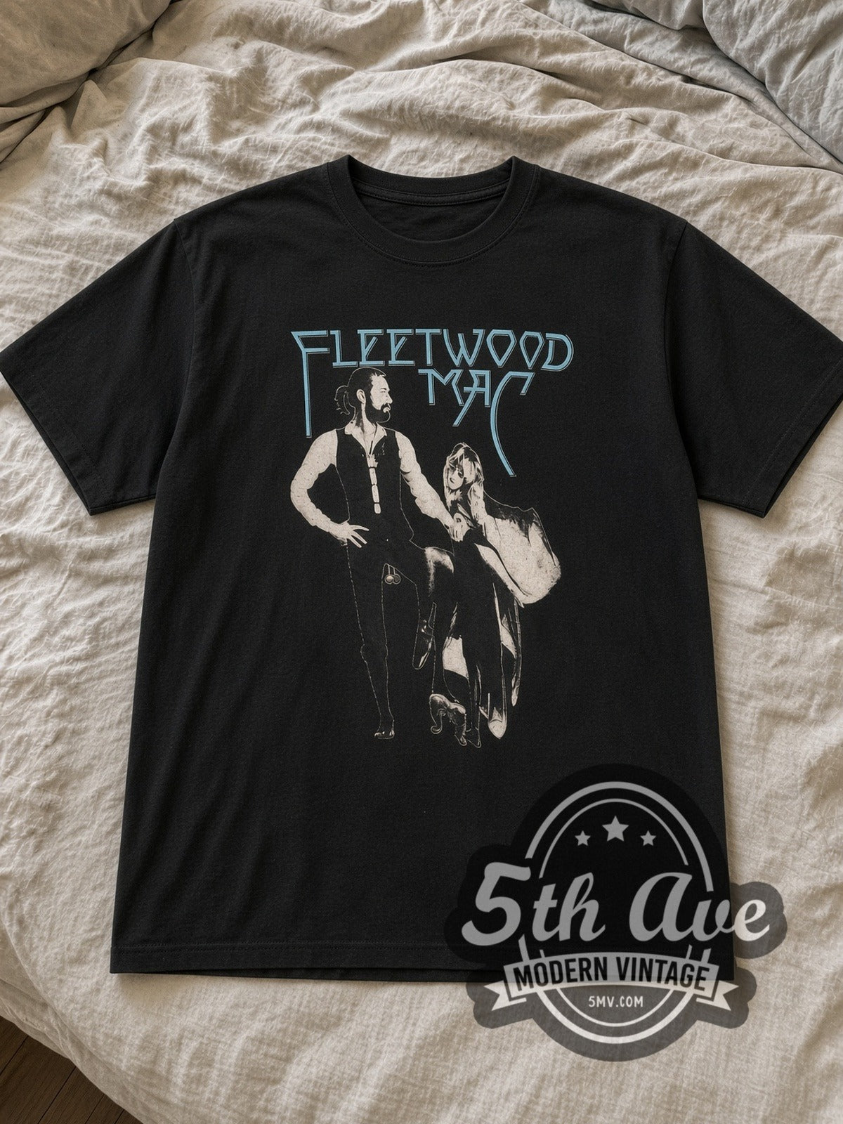 Black Fleetwood Mac Vintage Band T-Shirt laid flat on a linen bed