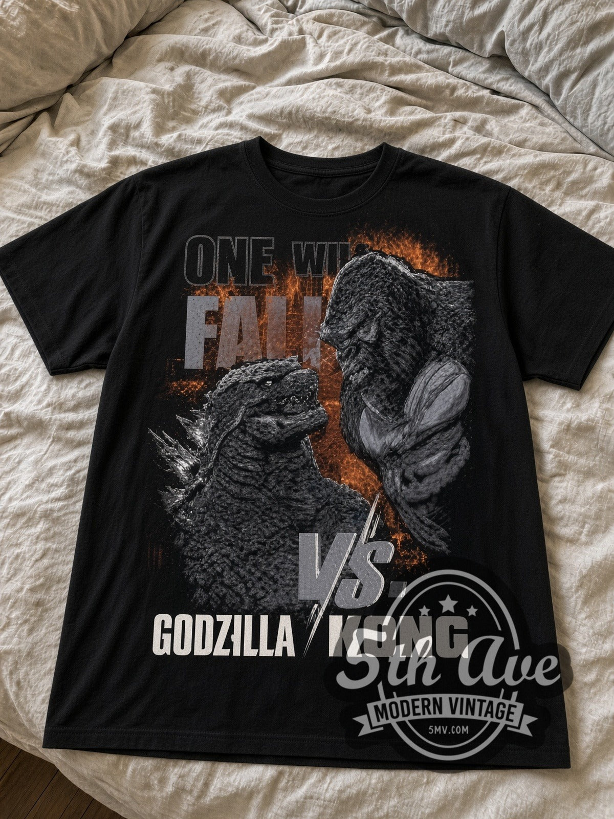 Godzilla vs. Kong One Will Fall black graphic tee laid flat on linen bed