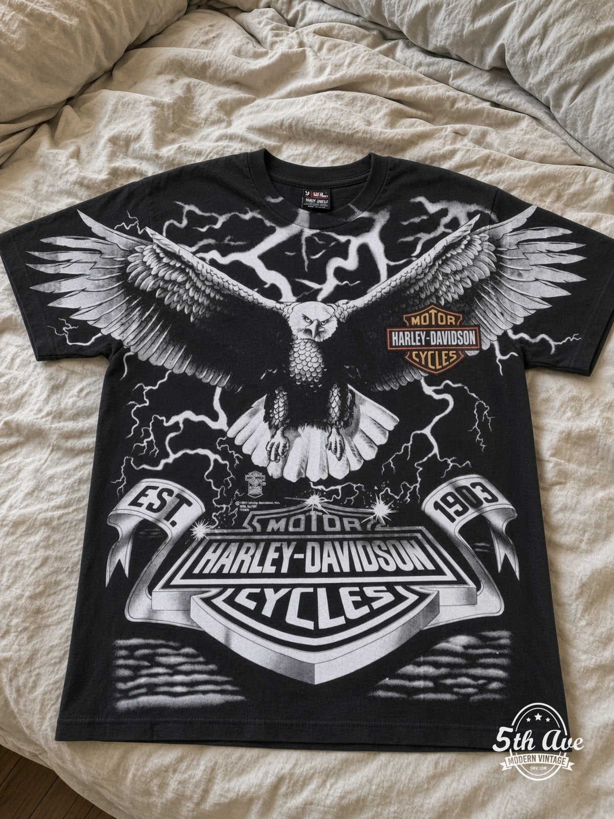 Harley-Davidson Eagle Lightning EST 1903 all over print vintage tee laid on bed