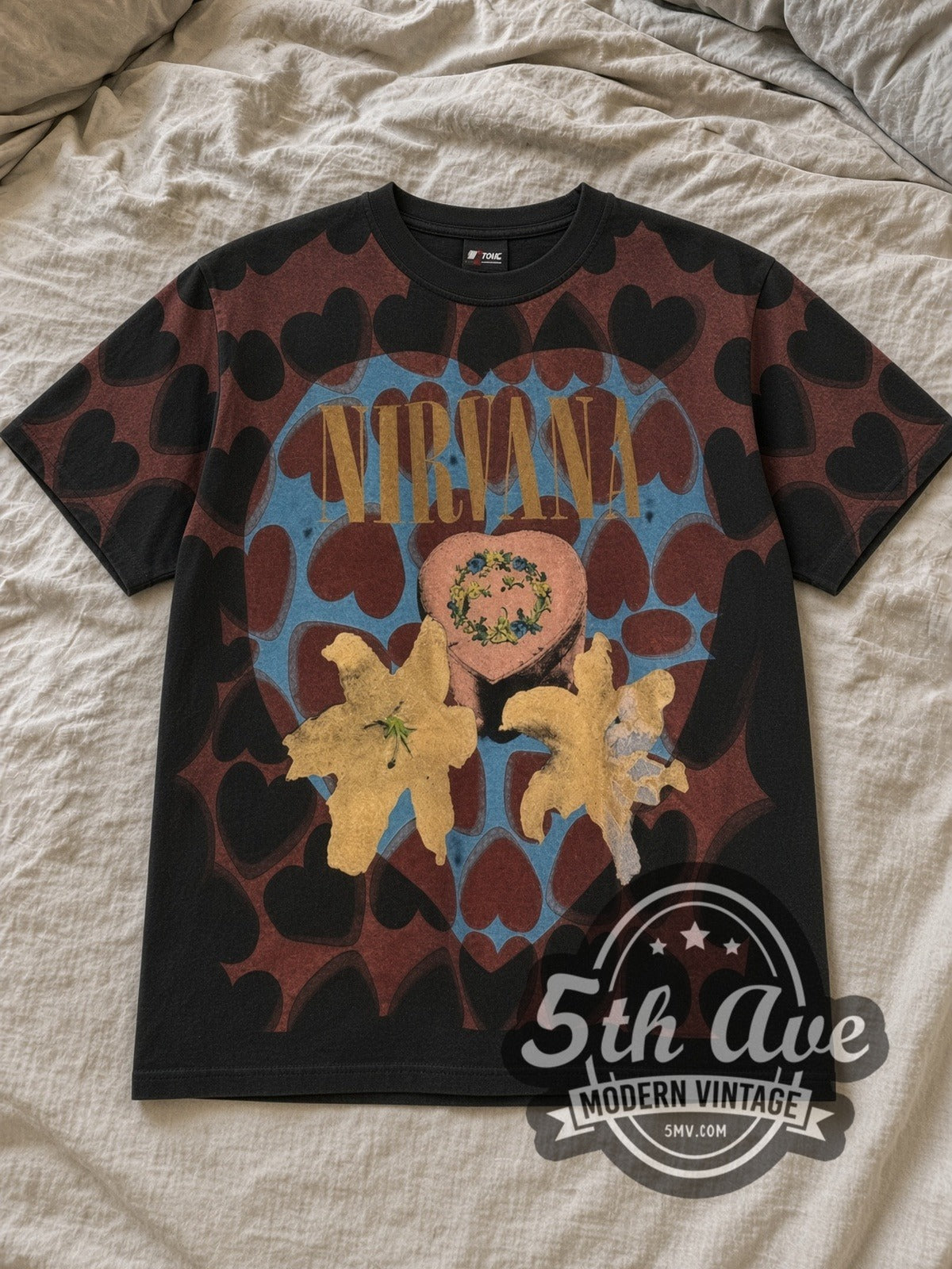 Black Nirvana Heart Shaped Box All Over Print Vintage Band T-Shirt laid flat on a linen bed