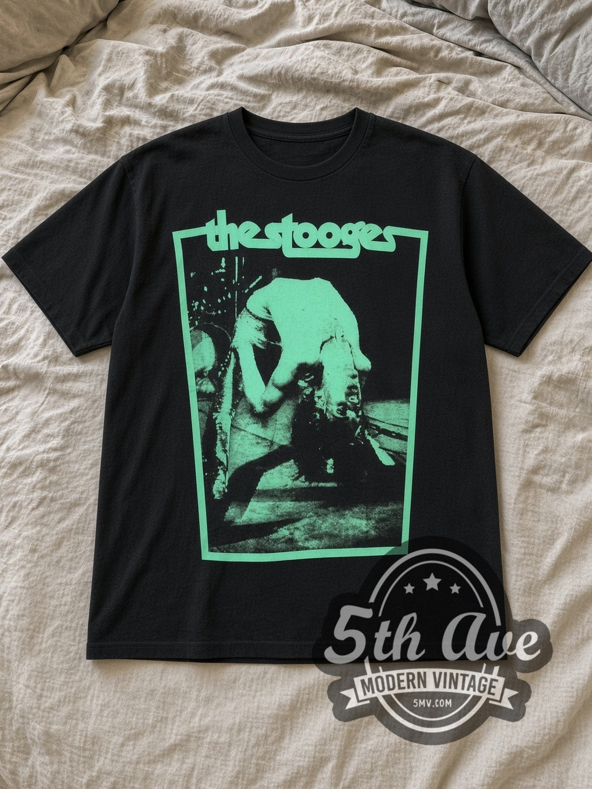 Black Iggy and The Stooges Turquoise Bend Vintage Band T-Shirt laid flat on a linen bed