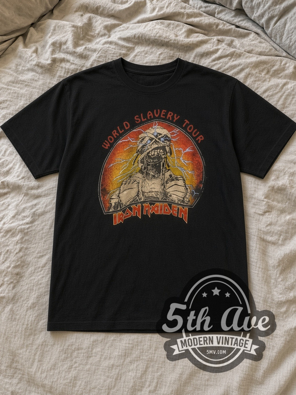 Black Iron Maiden World Slavery Tour Vintage Band T-Shirt laid flat on a linen bed