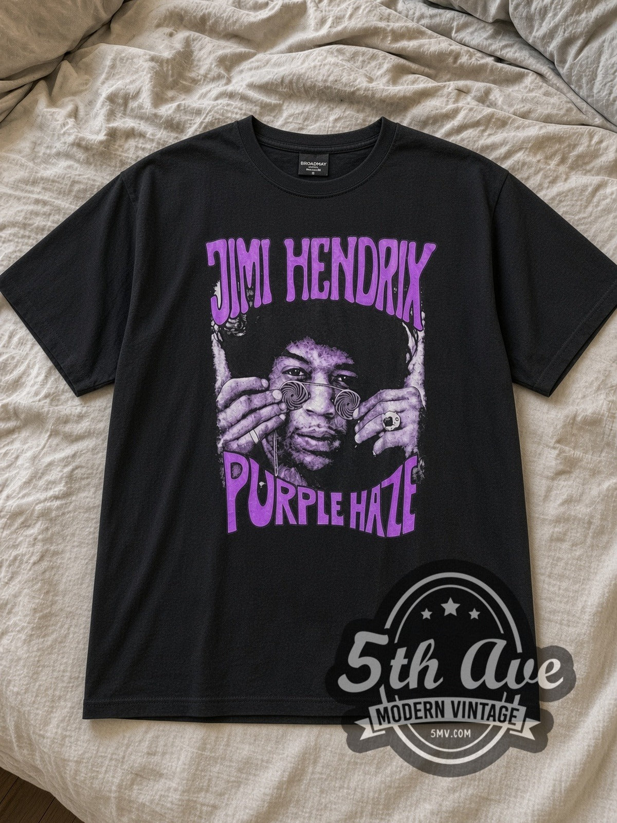 Black Jimi Hendrix Purple Haze Vintage Band T-Shirt laid flat on a linen bed