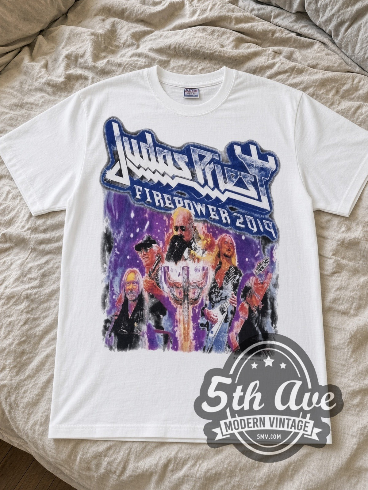 Judas Priest Firepower Metal Fist Tour Dates band t-shirt in white laid flat on a bed, front artwork