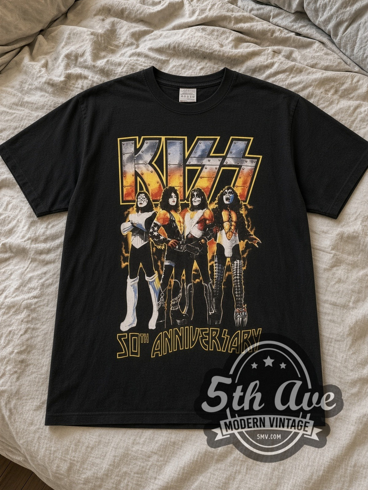 Black KISS 50th Anniversary Vintage Band T-Shirt laid flat on a linen bed