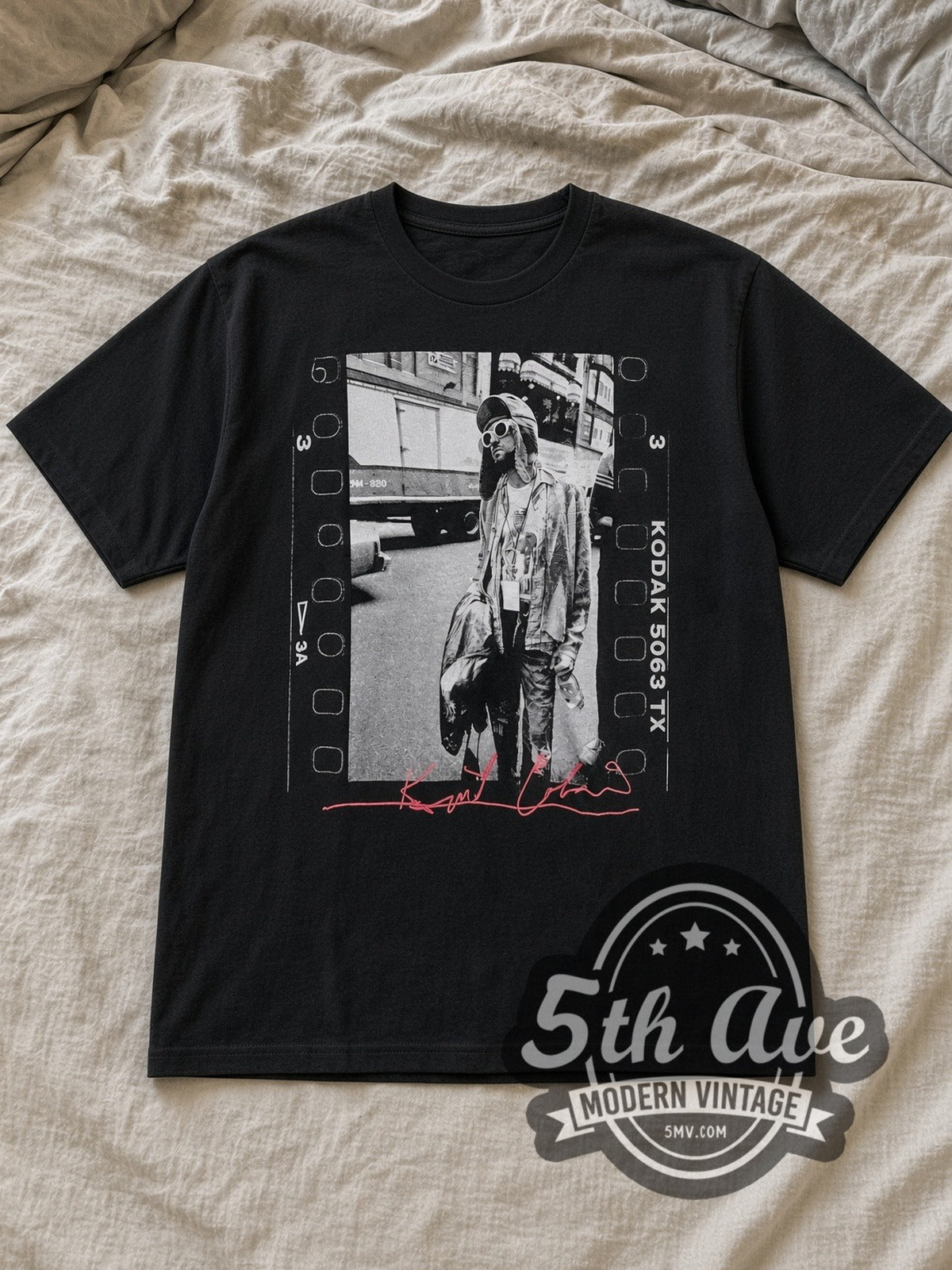 Black Nirvana Kurt Cobain Film Strip Pink Signature Vintage Band T-Shirt laid flat on a linen bed