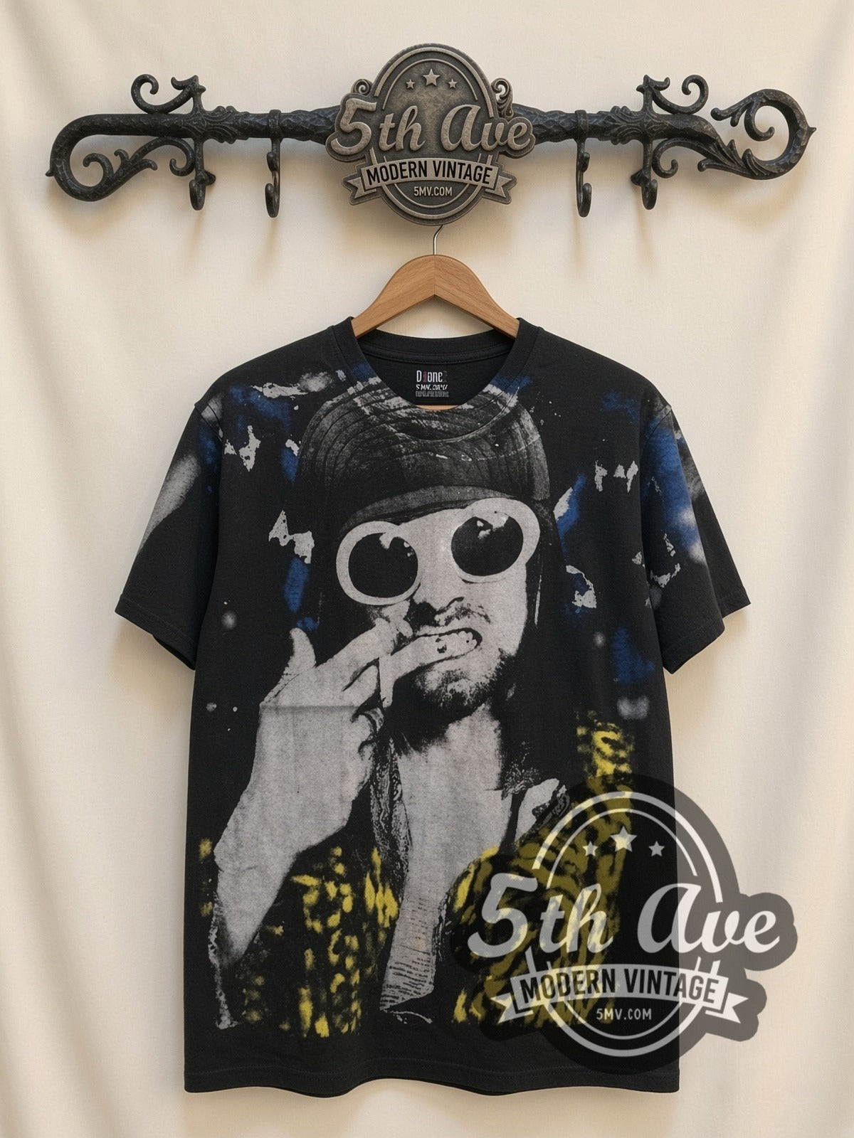 Kurt Cobain Sunglasses Leopard all-over-print vintage band tee in black, front view on a display rack