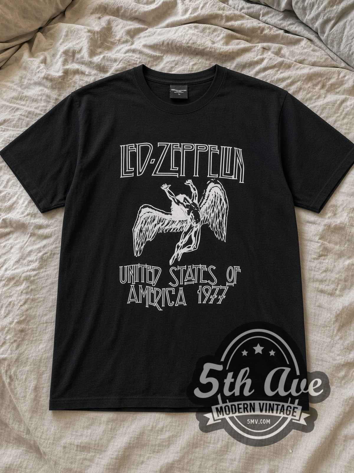 Black Led Zeppelin United States of America 1977 Vintage Band T-Shirt laid flat on a linen bed