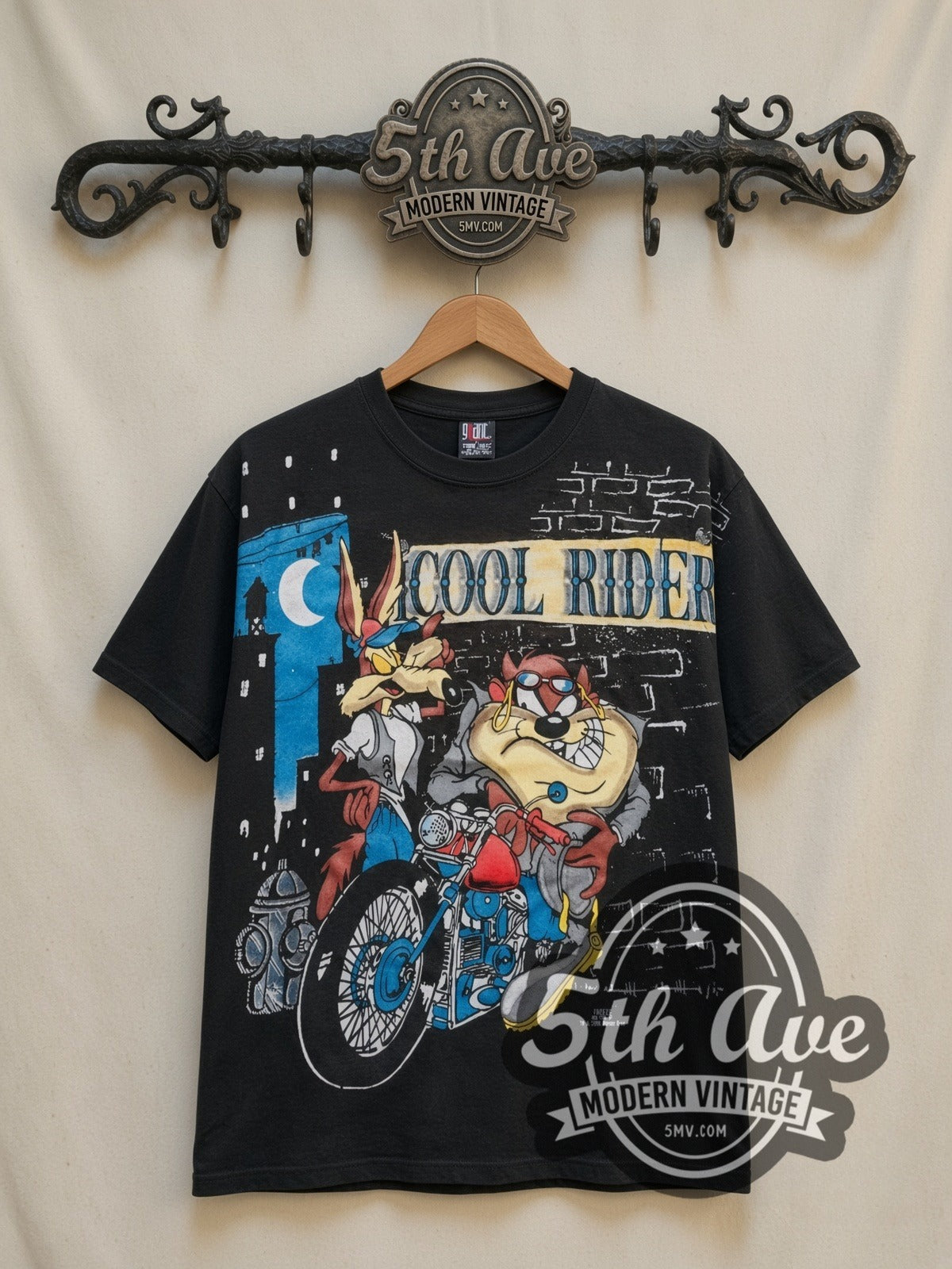 Looney Tunes Cool Riders Taz & Wile E all-over-print vintage cartoon t-shirt in black, front view on a display rack