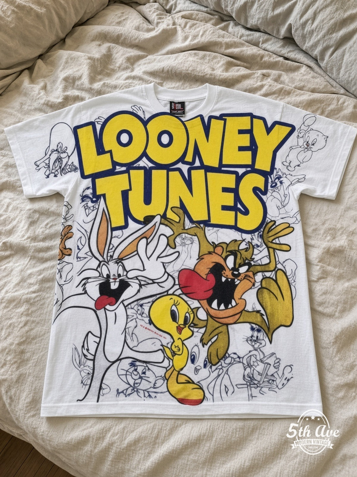 Looney Tunes Logo Bugs Tweety Taz Crew vintage tee laid on bed