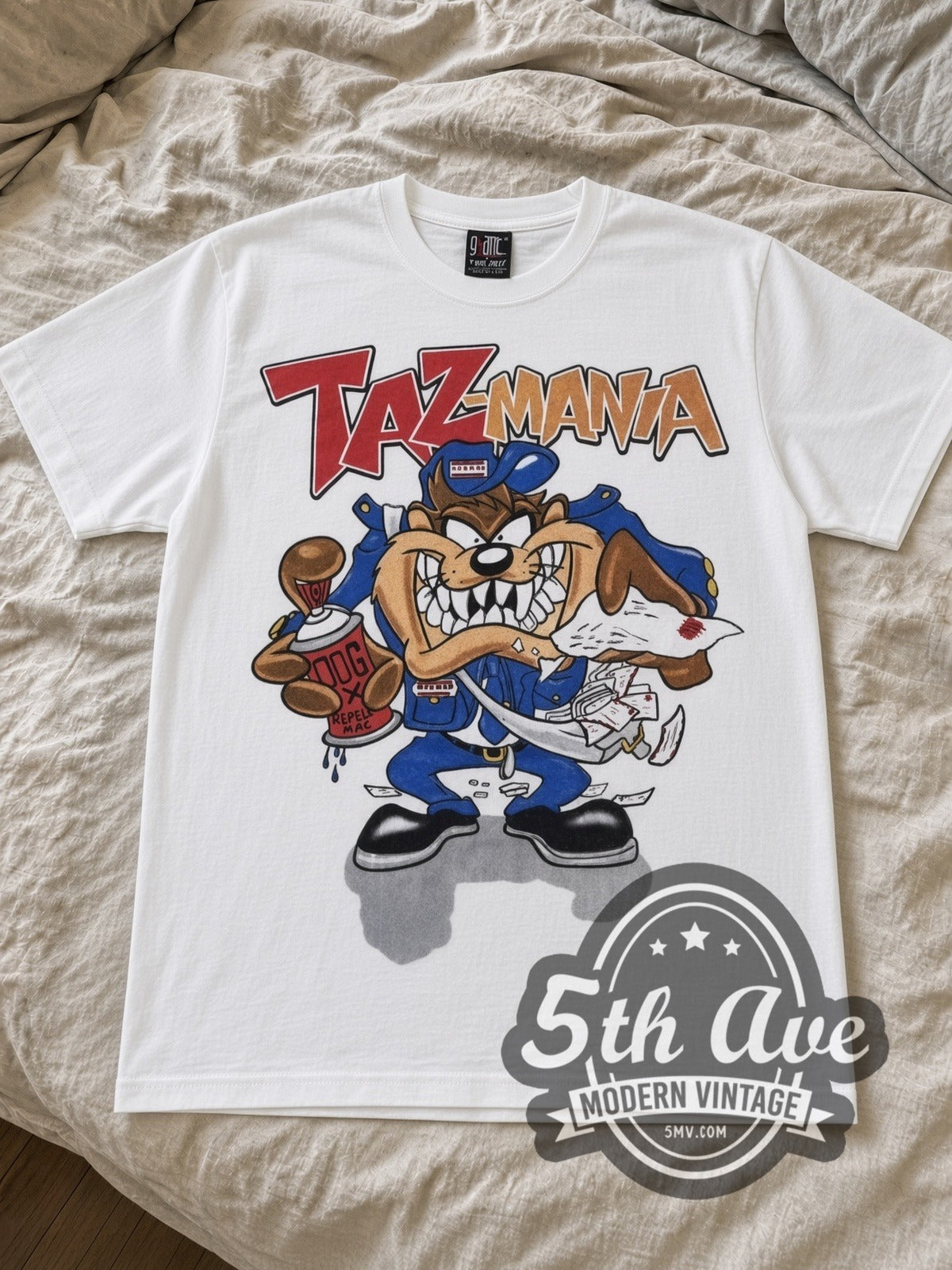 Looney Tunes Taz Hip-Hop Streetwear with Gossamer cartoon tee in white laid flat on a bed, front artwork