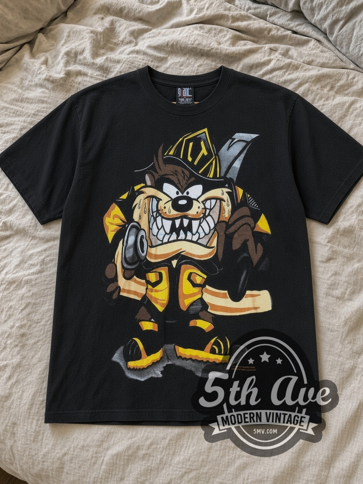 Black Looney Tunes Taz Mania Fire Department All Over Print Vintage Cartoon T-Shirt laid flat on a linen bed