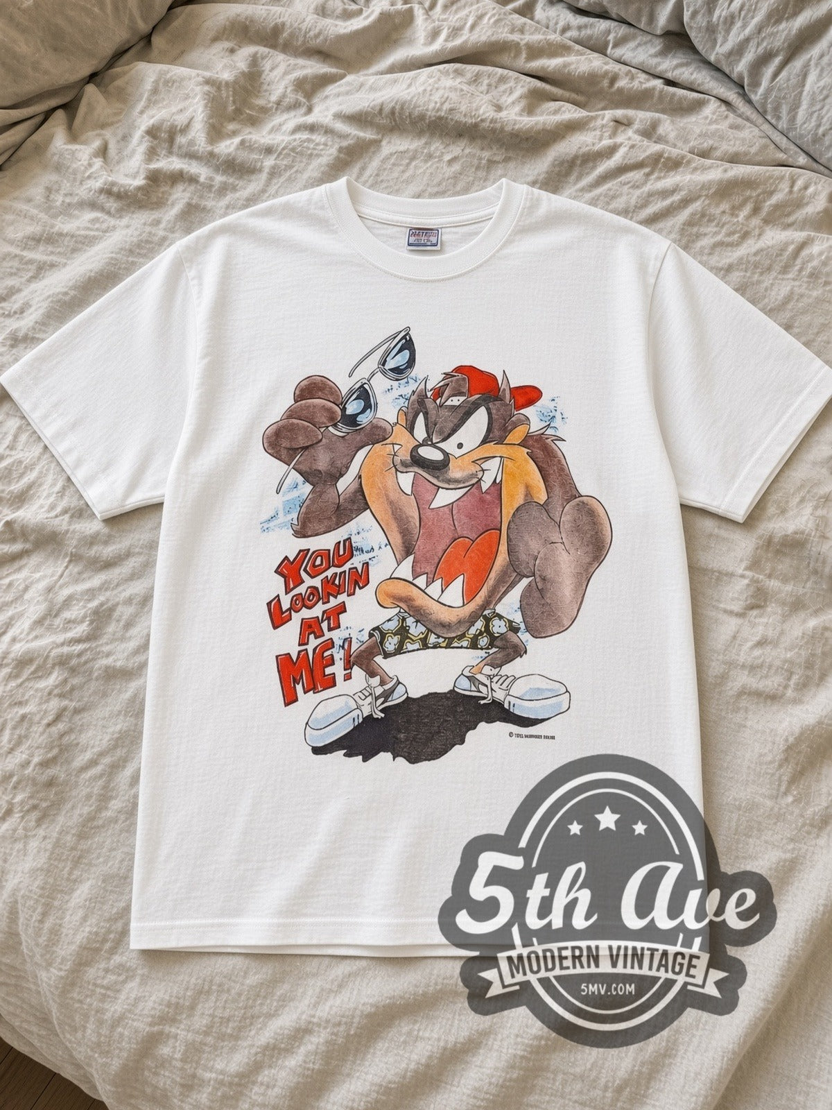 White Looney Tunes Taz Mania Skateboard Vintage Cartoon T-Shirt laid flat on a linen bed
