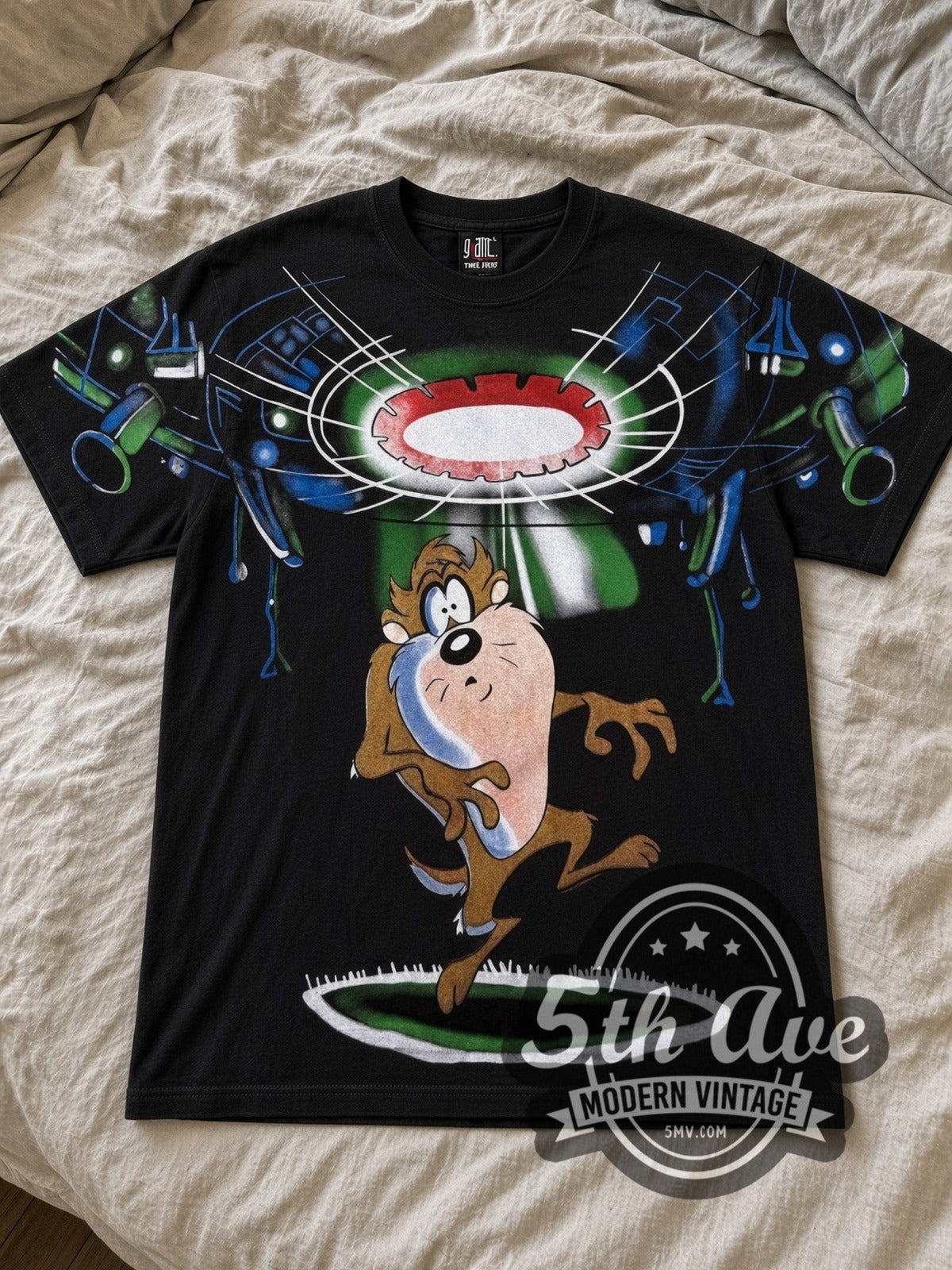 Looney Tunes Taz Rejected UFO cartoon tee in black laid flat on a bed, front artwork