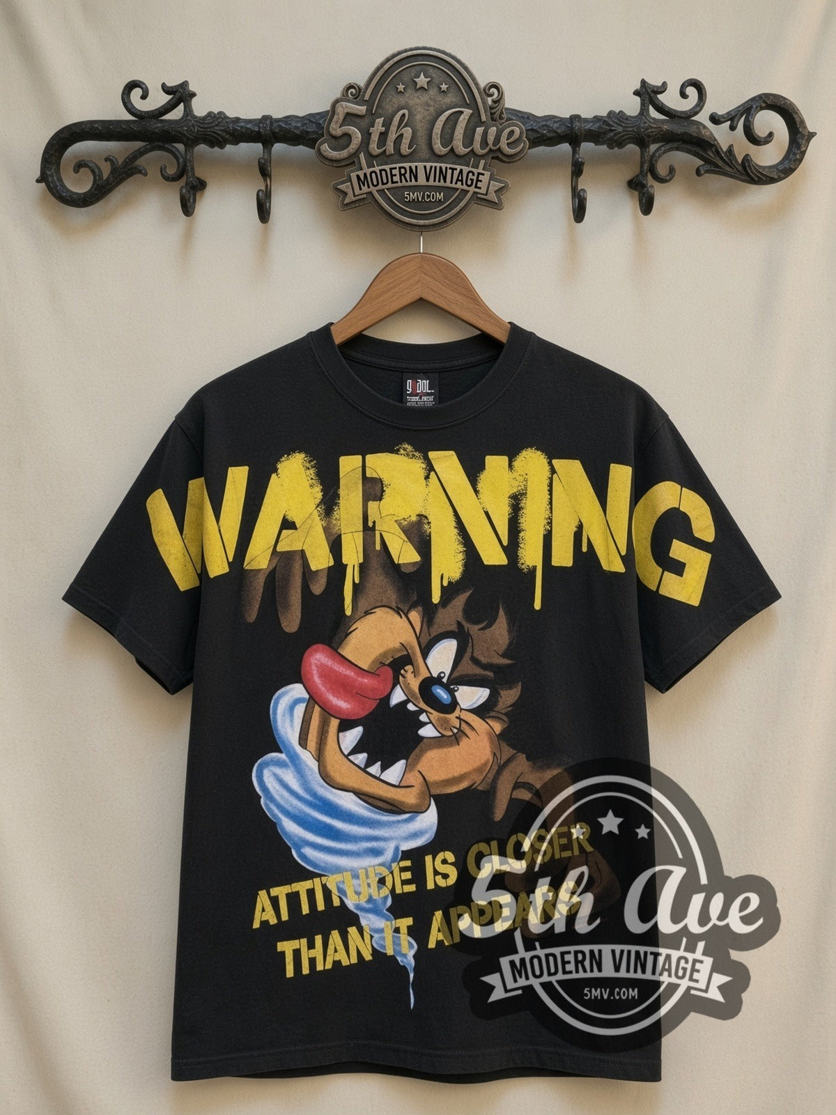 Looney Tunes Taz Warning Attitude Is Closer all-over-print vintage cartoon t-shirt in black, front view on a display rack