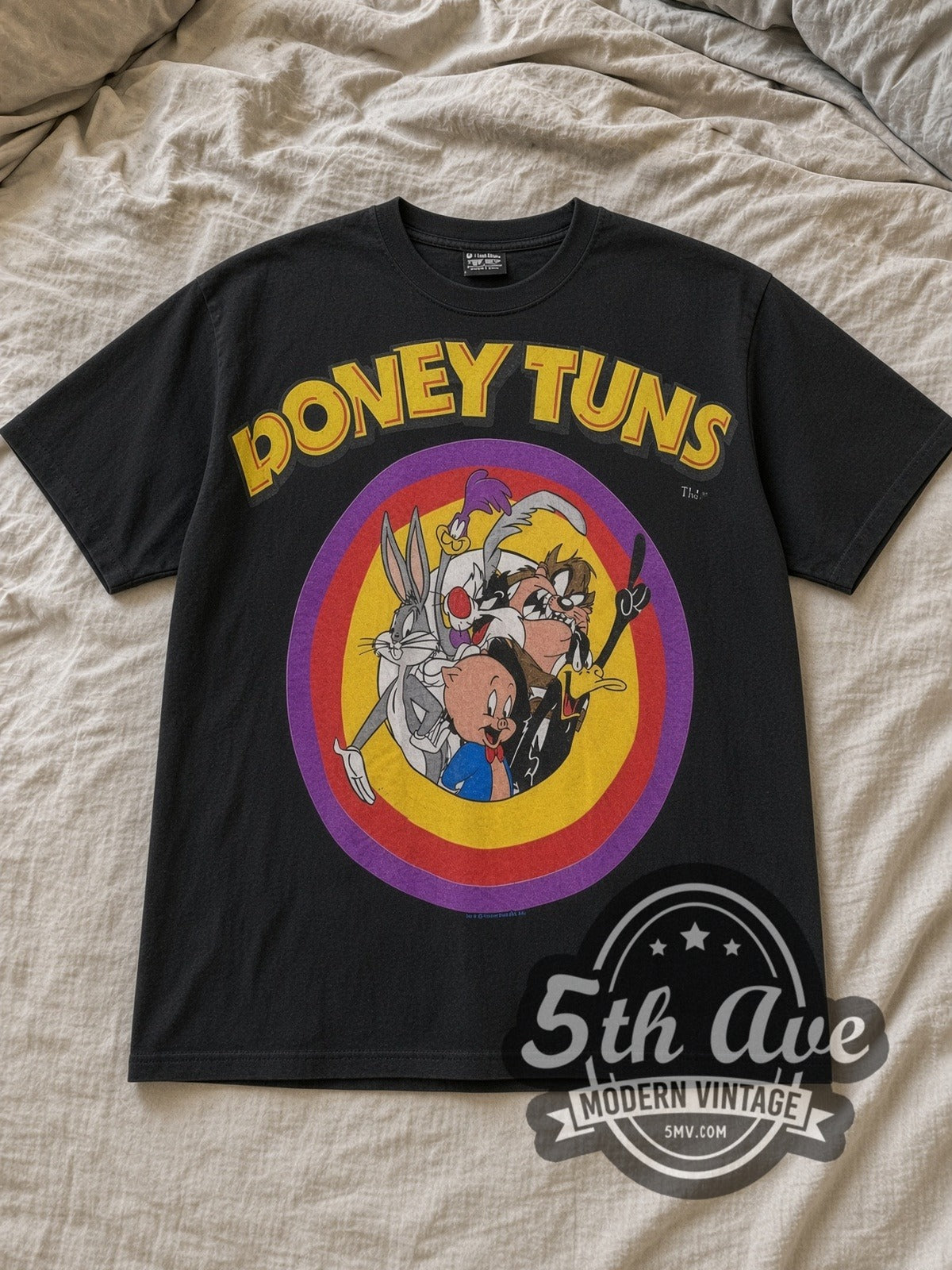 Black Looney Tunes TuneSquad Vintage Cartoon T-Shirt laid flat on a linen bed