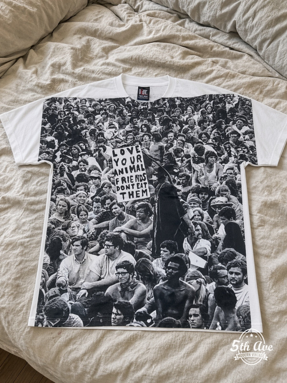 Love Your Animals Dont Eat Them Crowd all over print vintage tee laid on bed