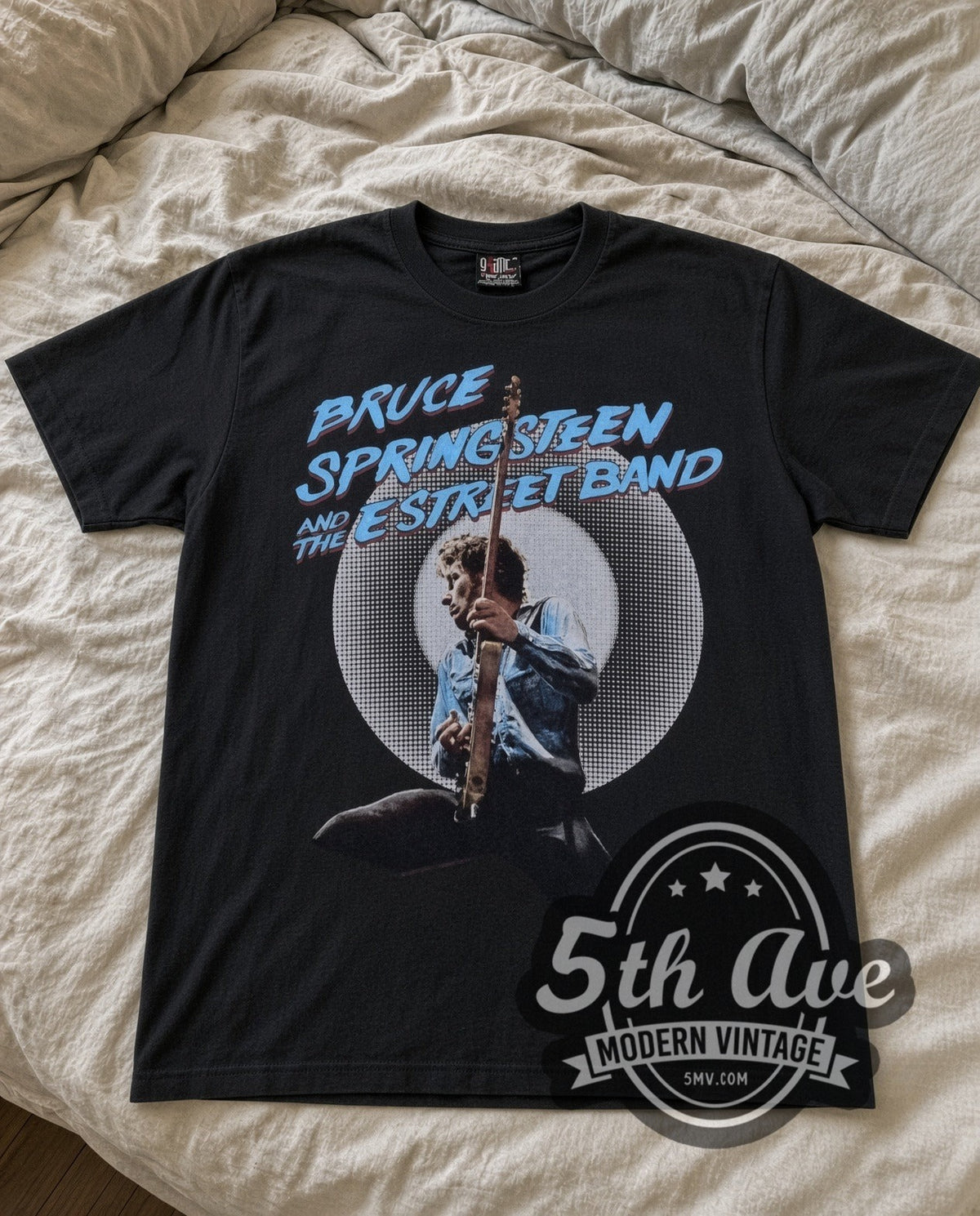 Bruce Springsteen E Street Band vintage band t-shirt in black laid flat on a bed, front artwork