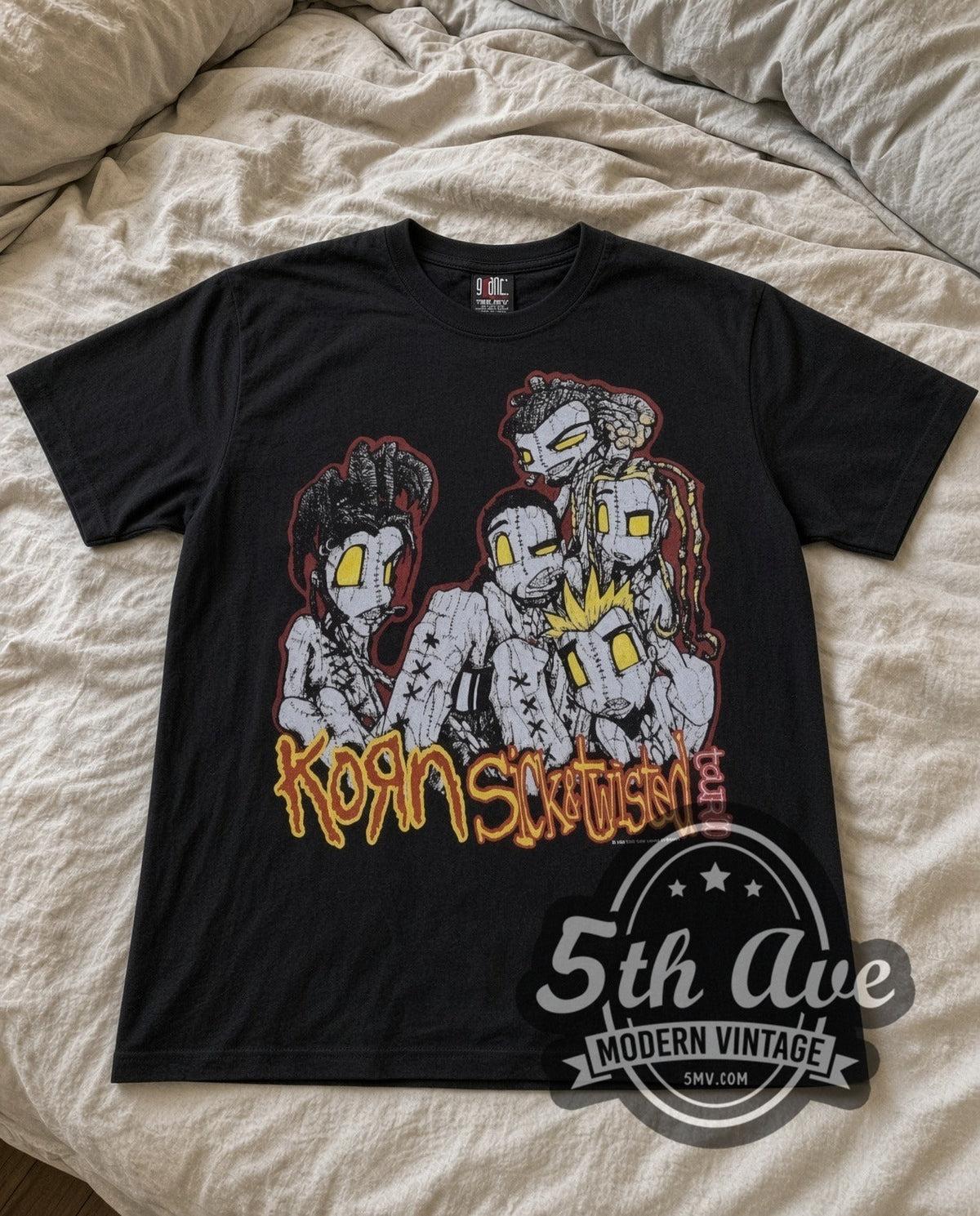 Korn Sick and Twisted Tour vintage band t-shirt in black laid flat on a bed, front artwork
