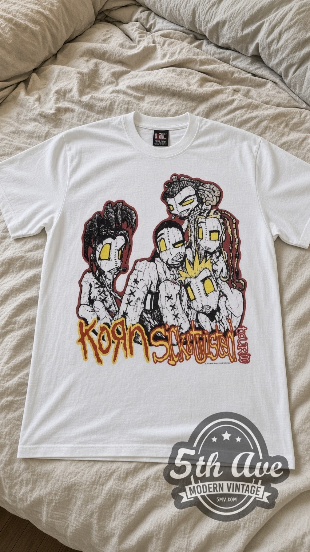 Korn Sick and Twisted Tour vintage band t-shirt in white laid flat on a bed, front artwork
