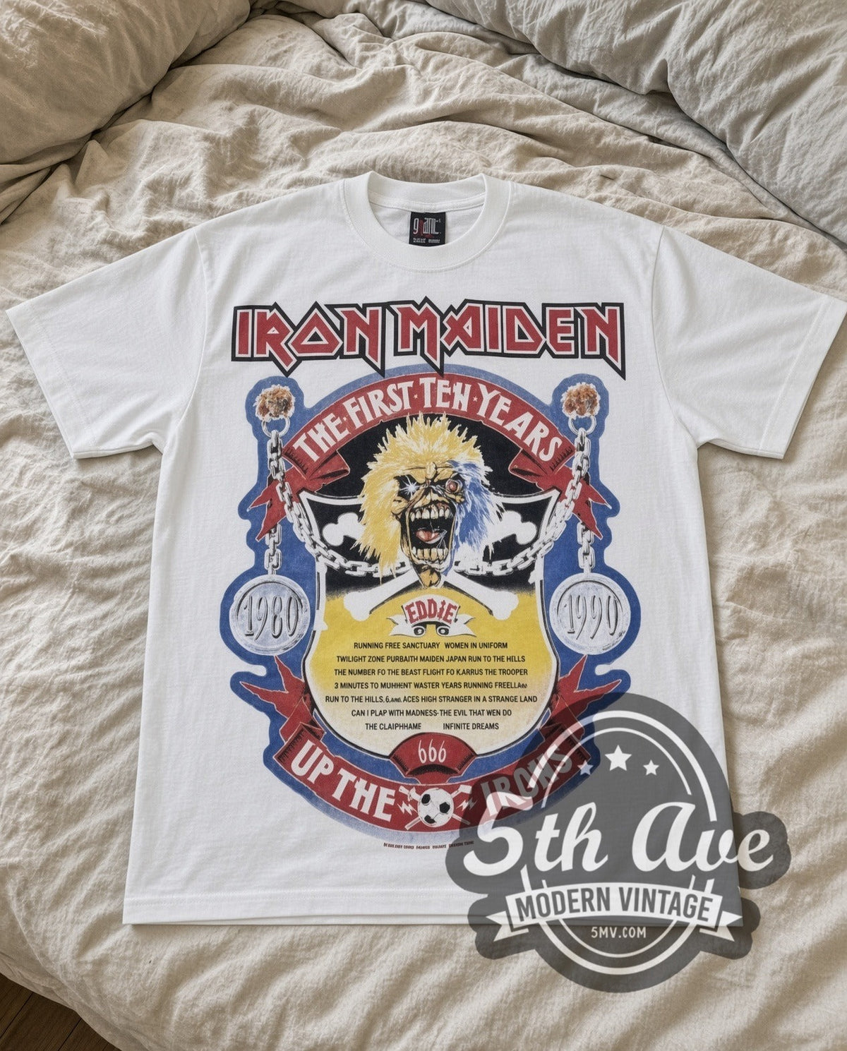 Iron Maiden First Ten Years vintage band t-shirt in white laid flat on a bed, front artwork