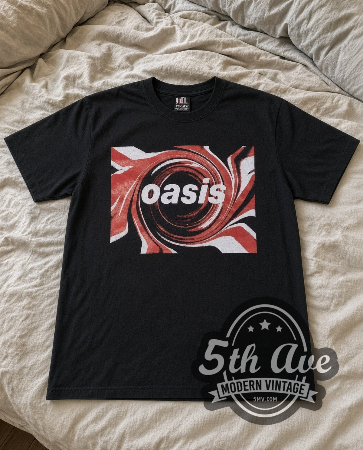 Oasis Swirl Logo vintage band t-shirt in black laid flat on a bed, front artwork