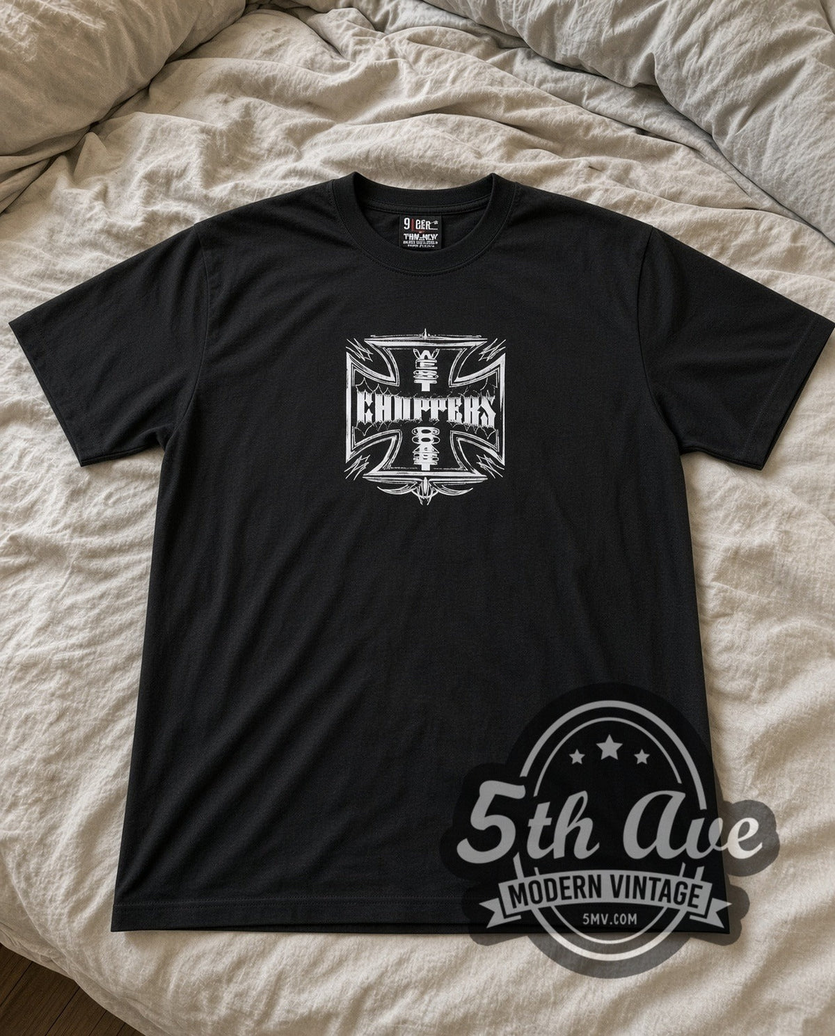 West Coast Choppers Iron Cross Vintage Motorsports graphic tee laid flat on a bed, front artwork