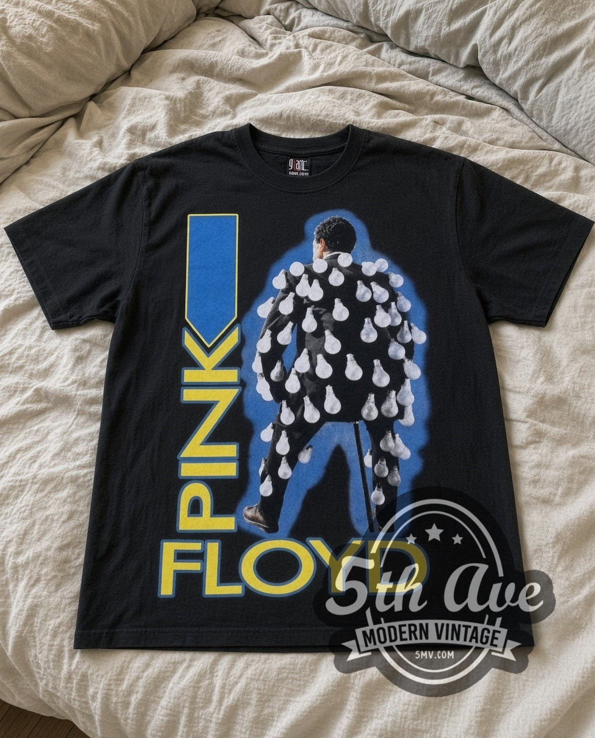 Pink Floyd Figure vintage band t-shirt in black laid flat on a bed, front artwork