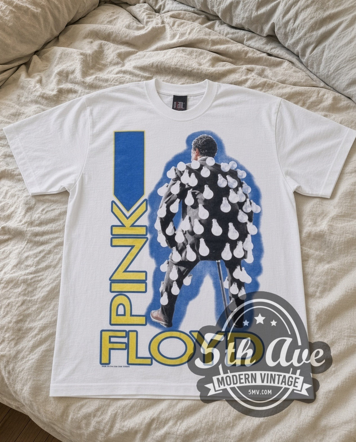 Pink Floyd Figure vintage band t-shirt in white laid flat on a bed, front artwork